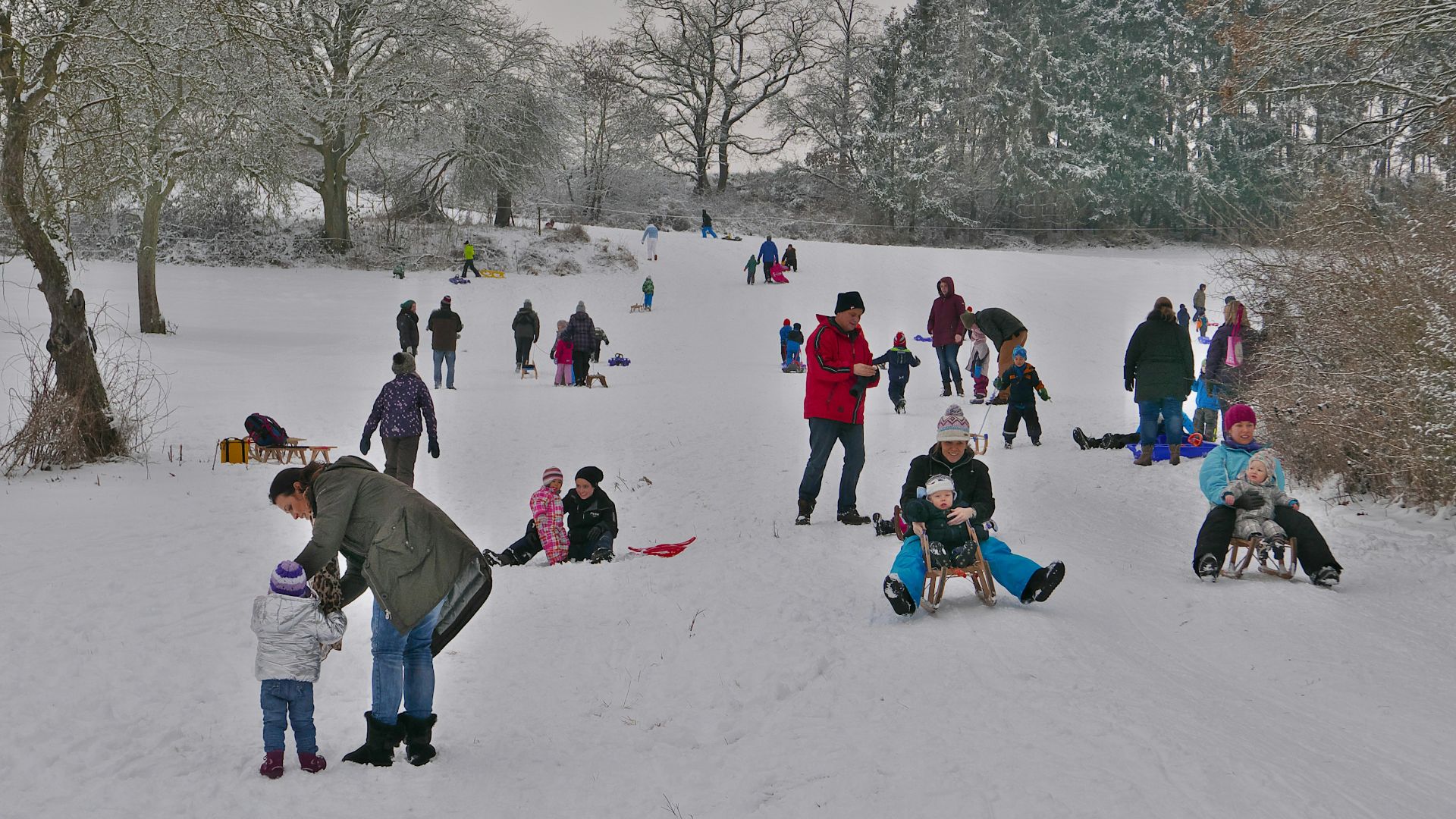 people sitting on snow covered ground during daytime