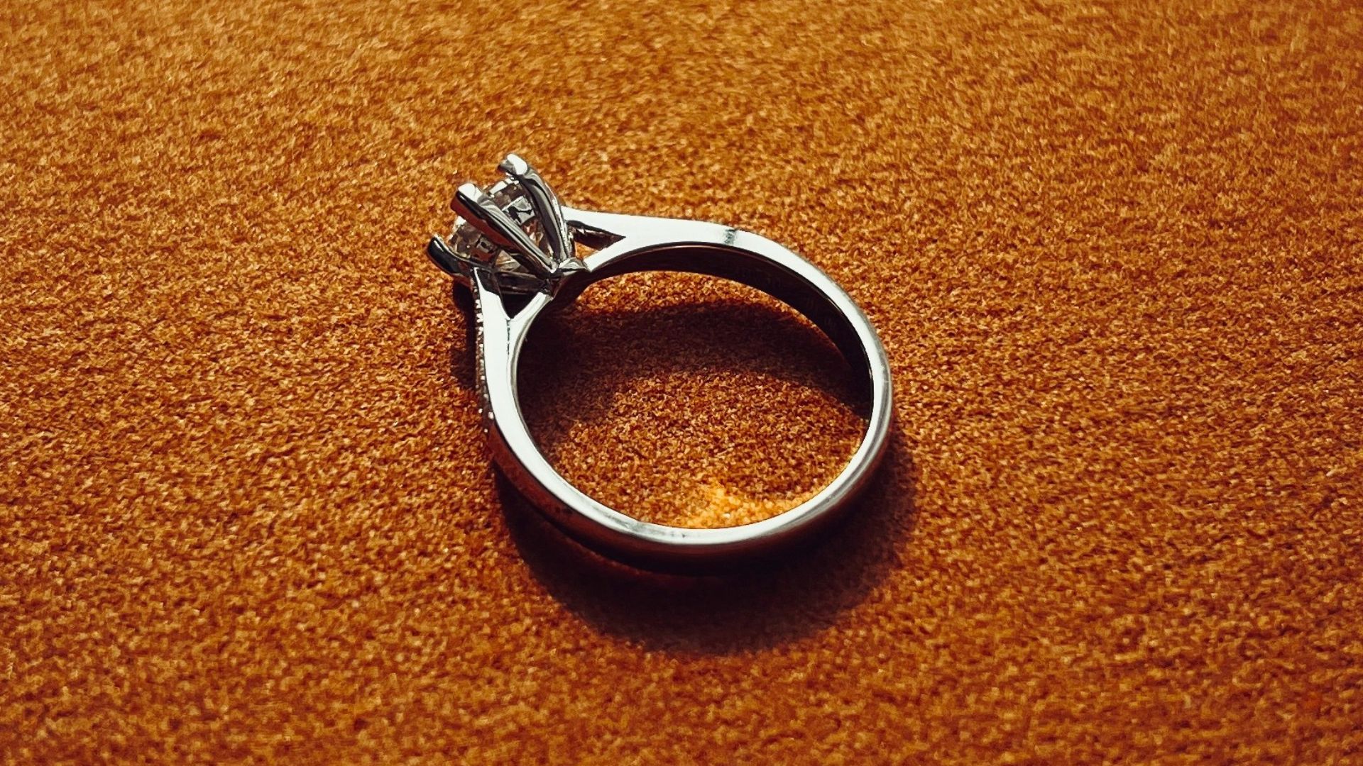 a silver ring sitting on top of a brown surface