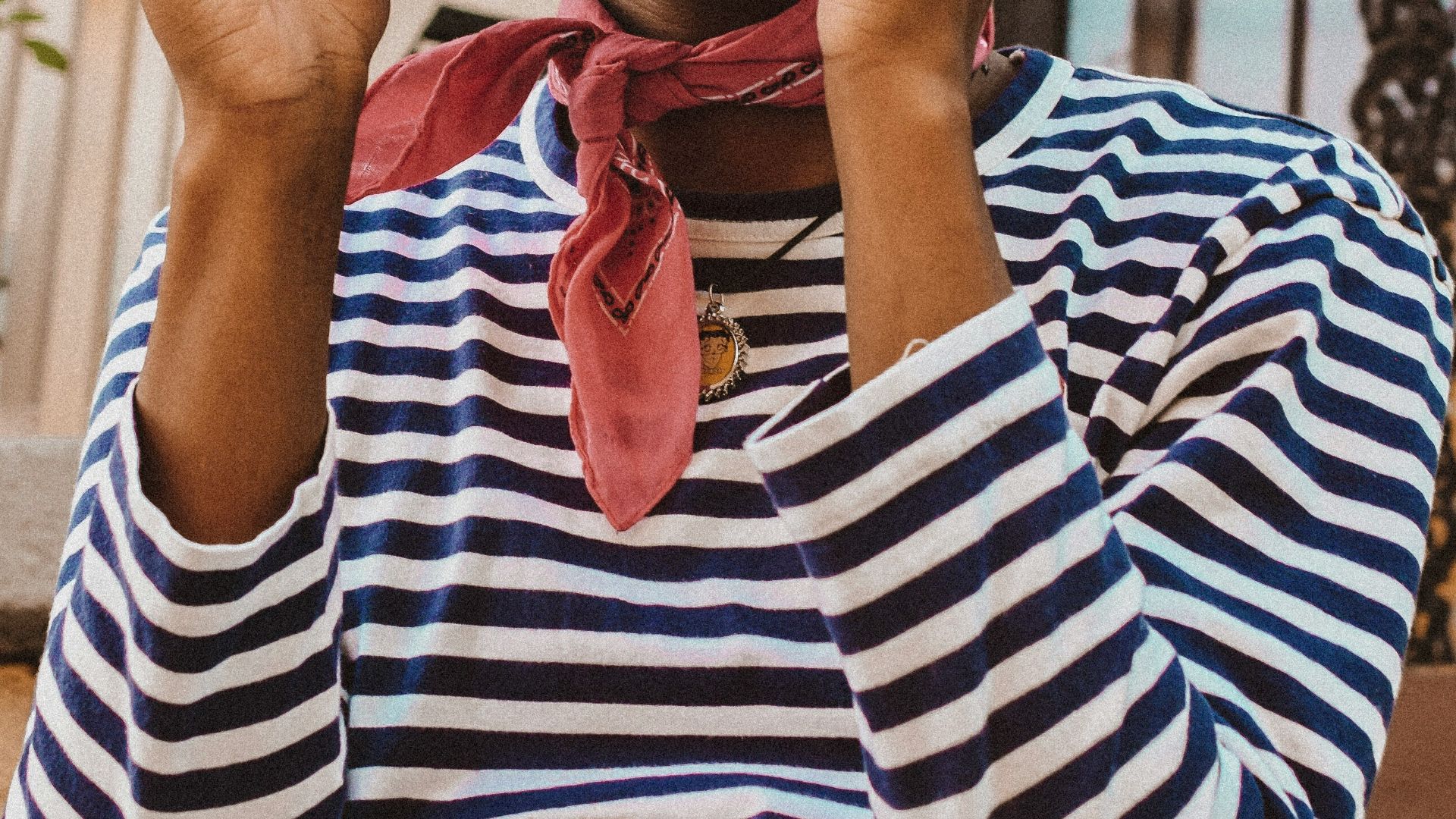 person in striped shirt holding round mirror