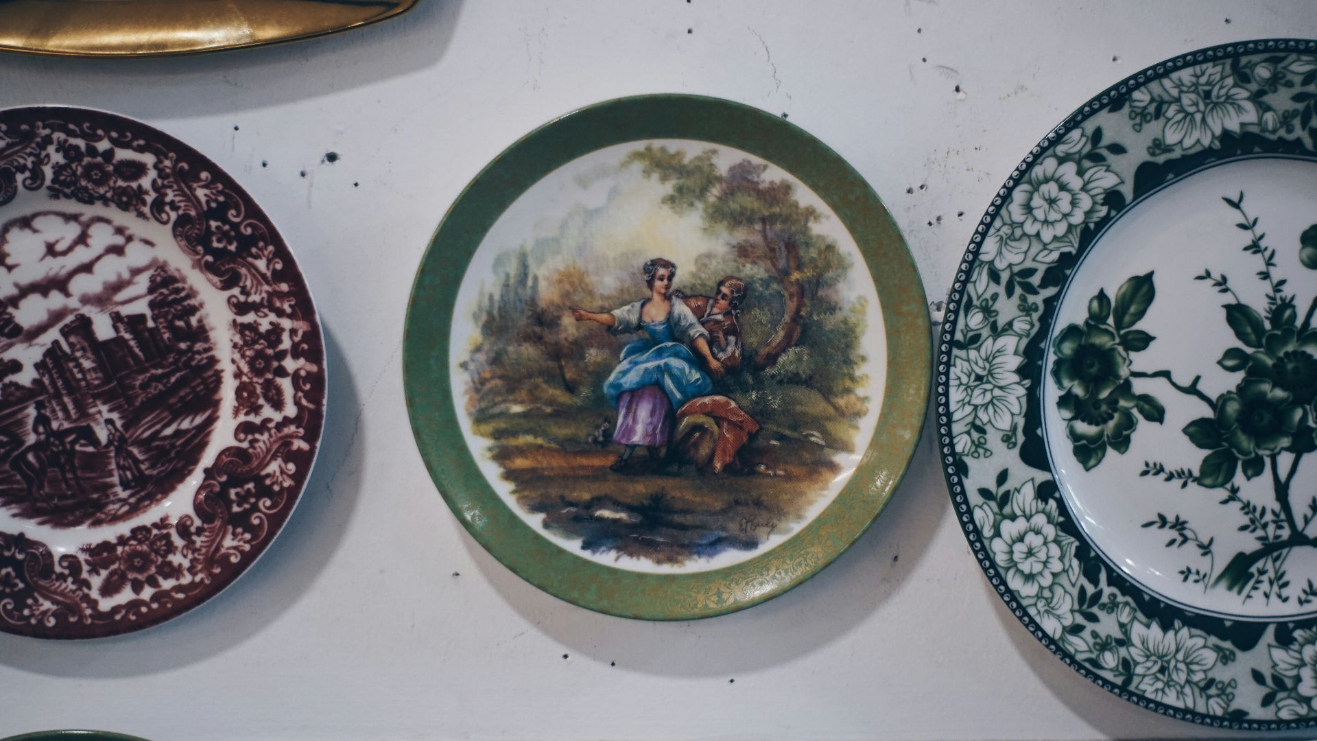 Collection of decorative plates with painted scenes.
