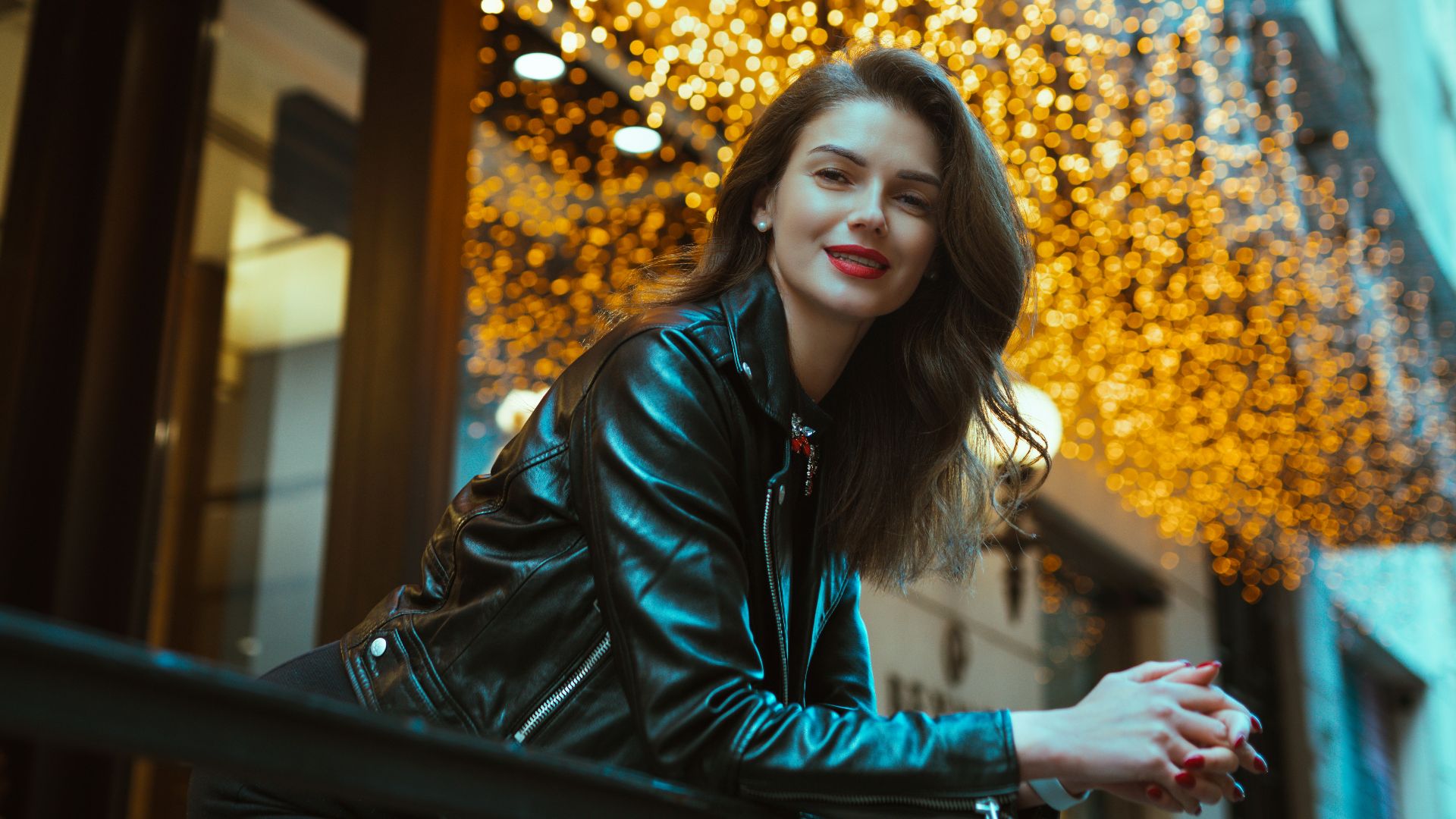 a woman leaning on a railing in front of a building
