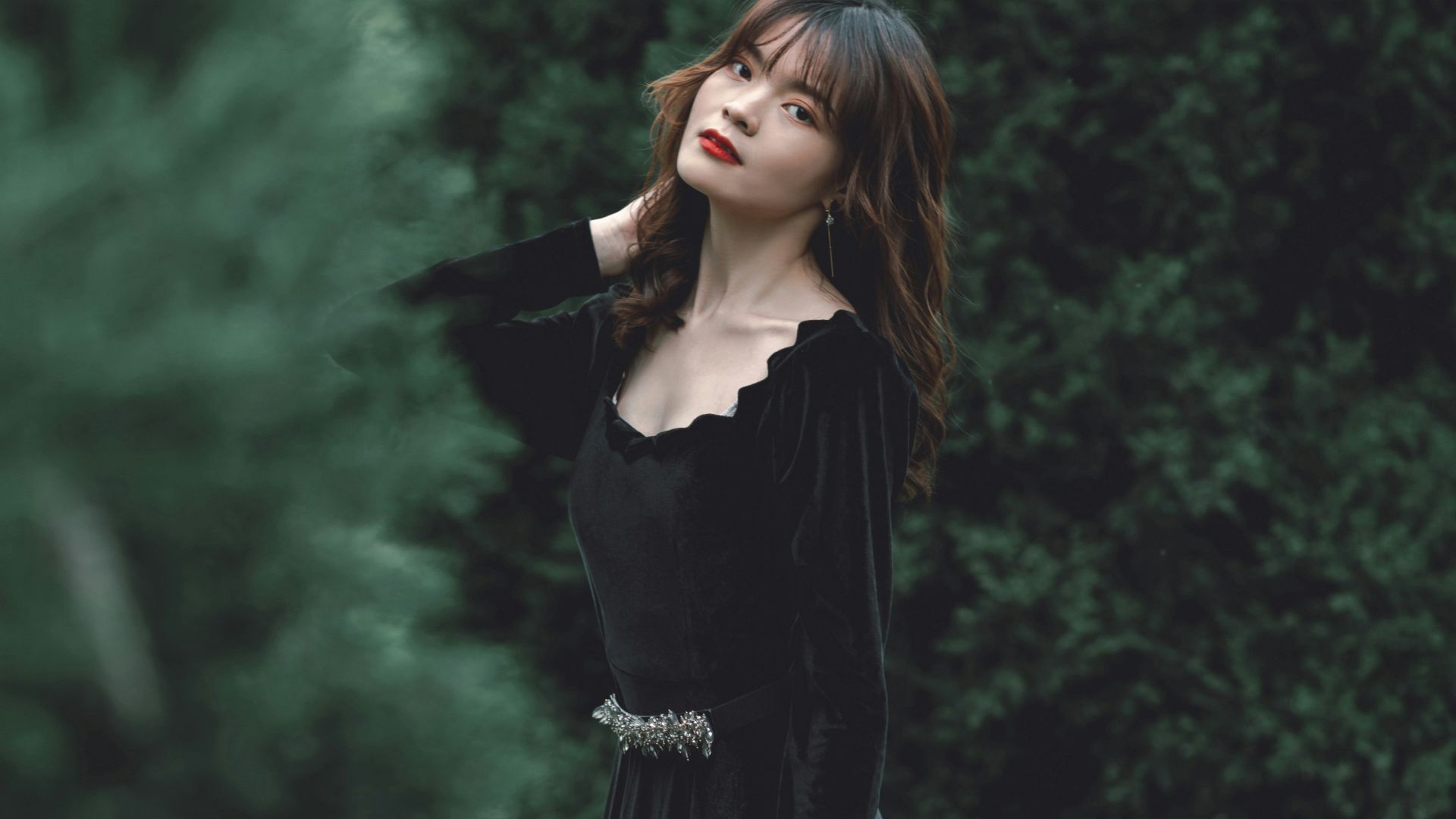 A woman in a black dress standing in a field