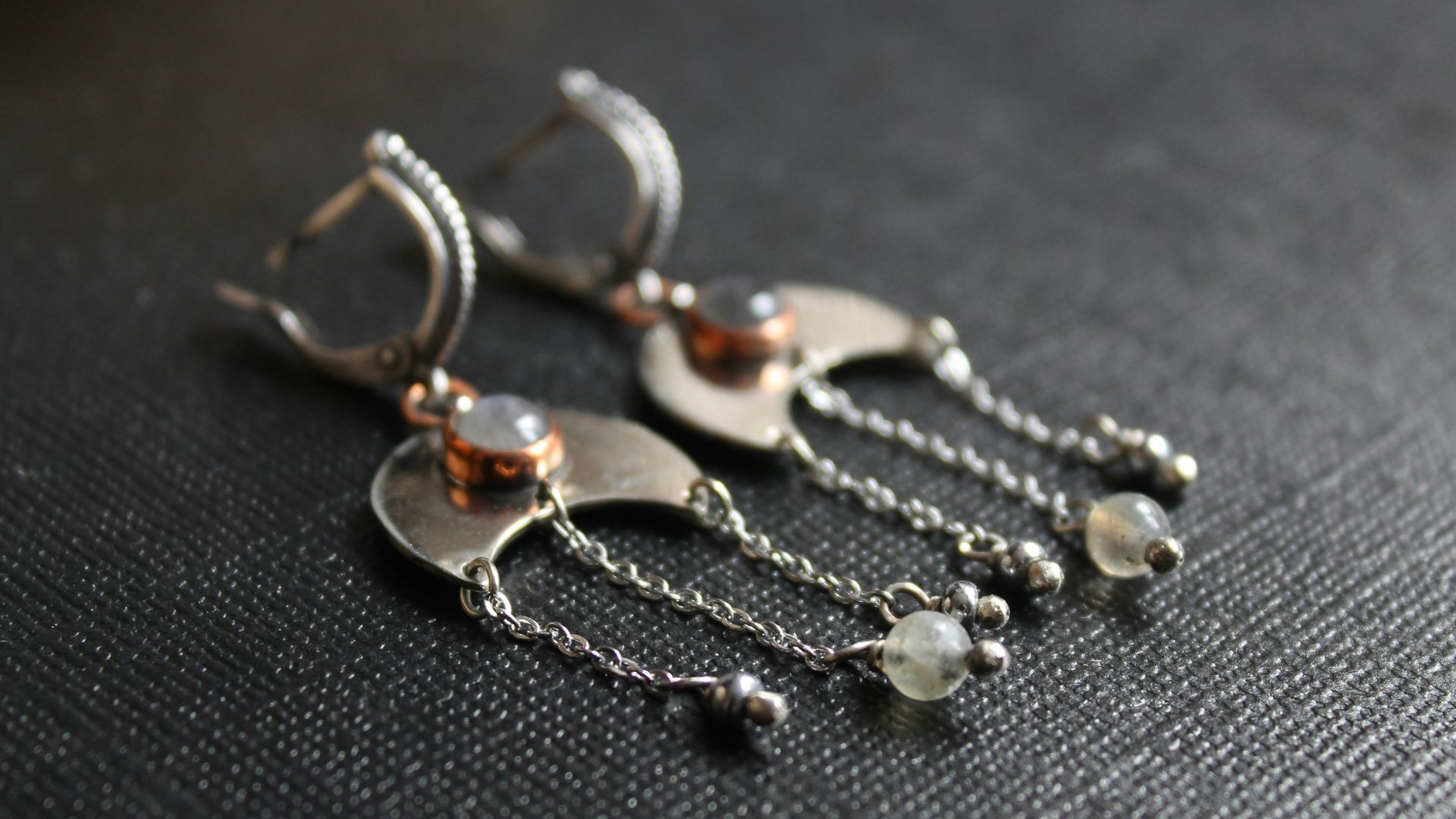 A pair of silver earrings with dangling beads