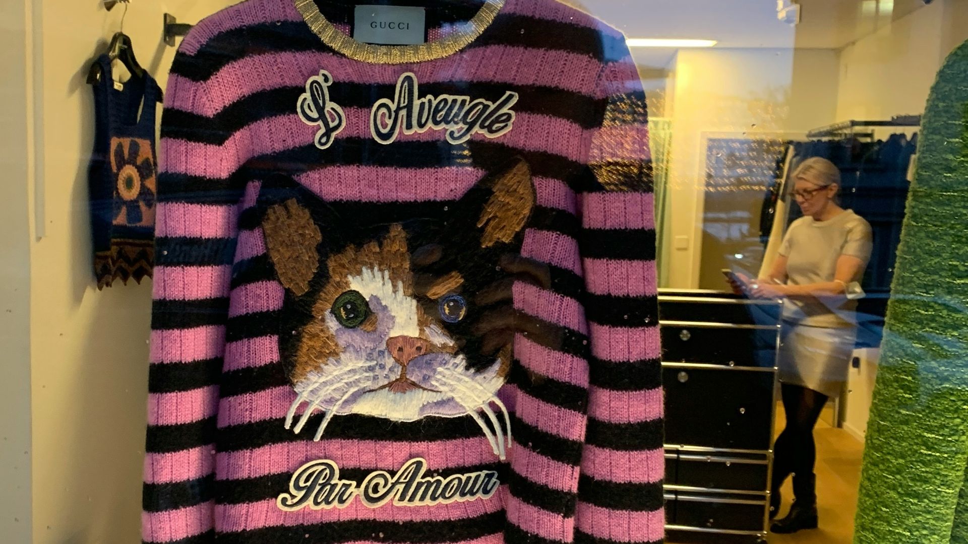 A pink and black striped shirt with a picture of a cat on it