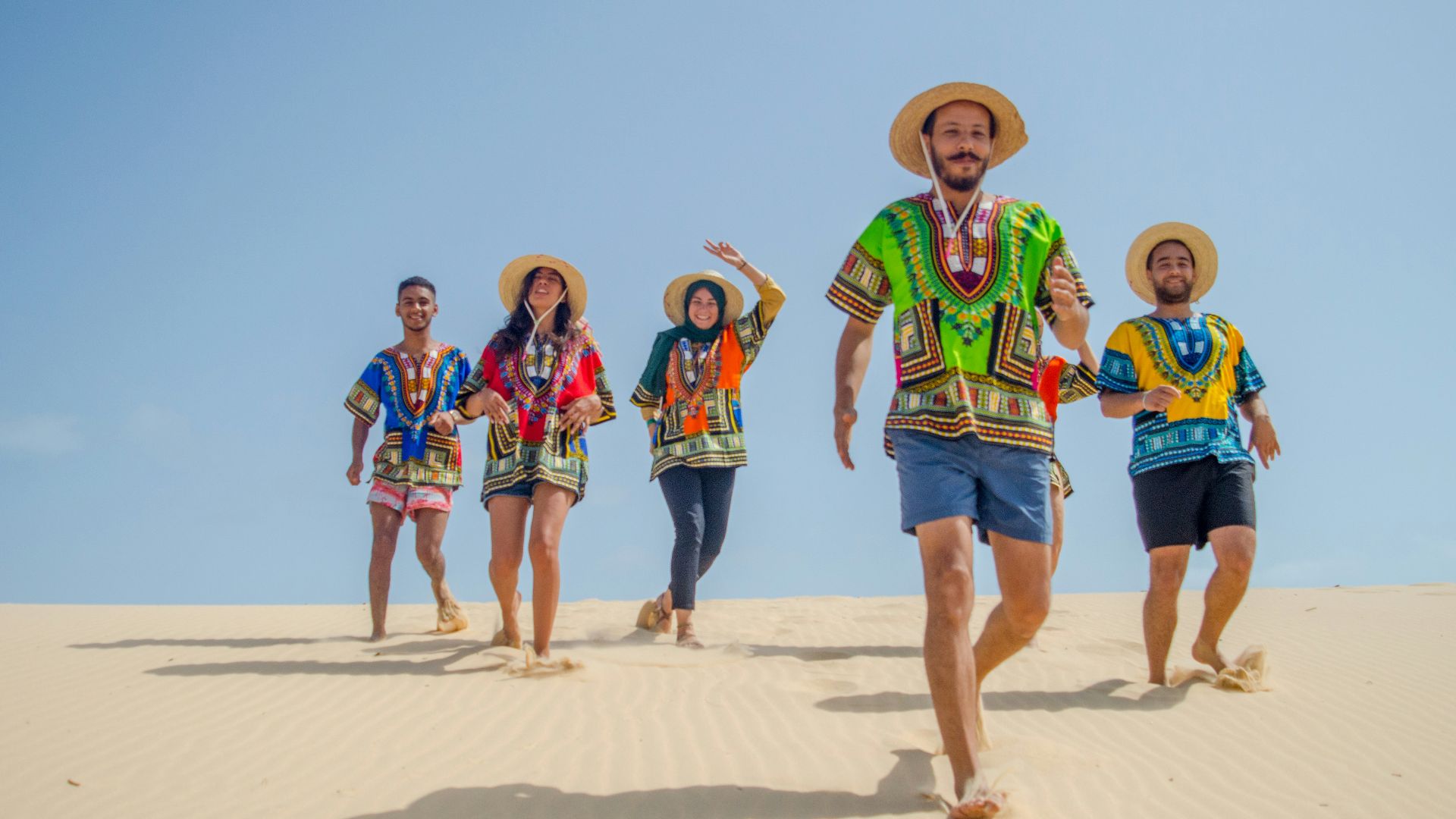 group of people running on brown sand during daytime