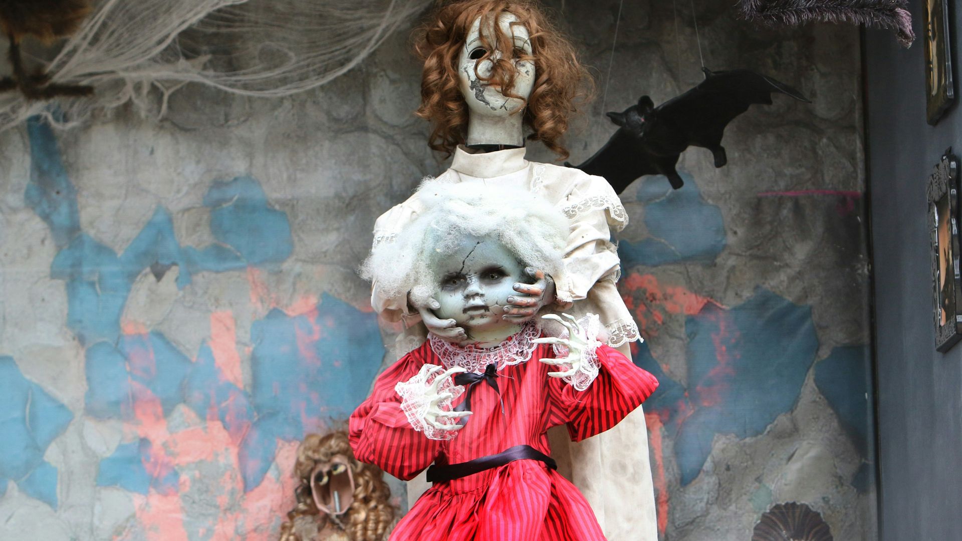 Two creepy dolls with tattered clothing and cobwebs