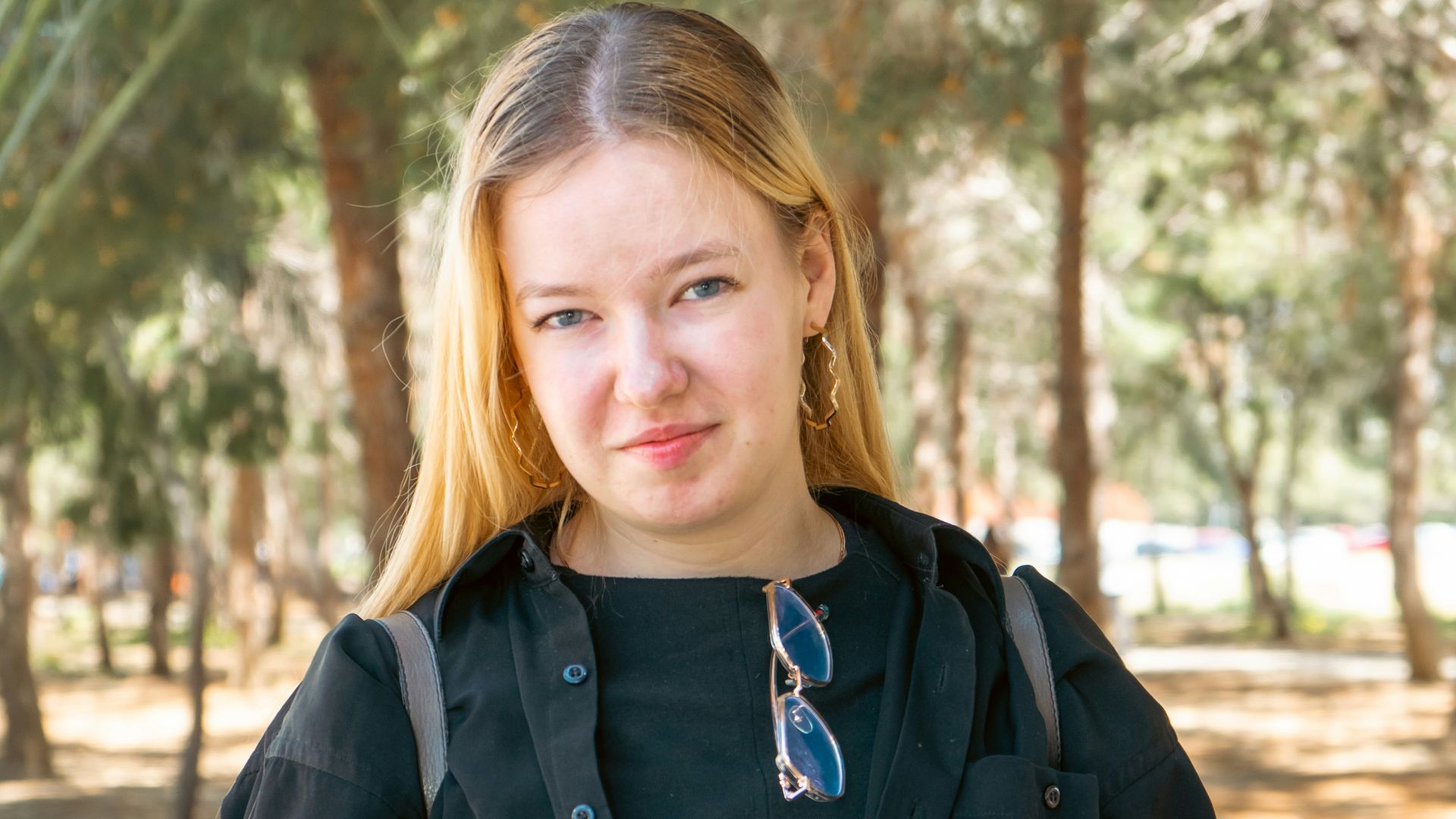 a woman in a black dress and jacket posing for a picture