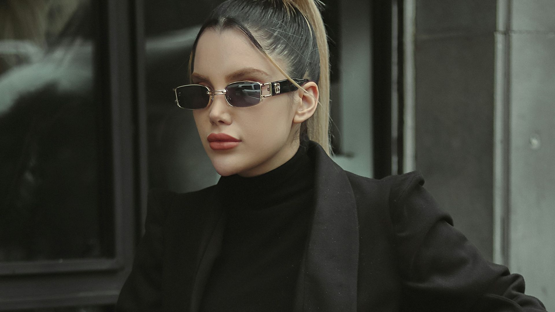a woman sitting at a table wearing a black outfit