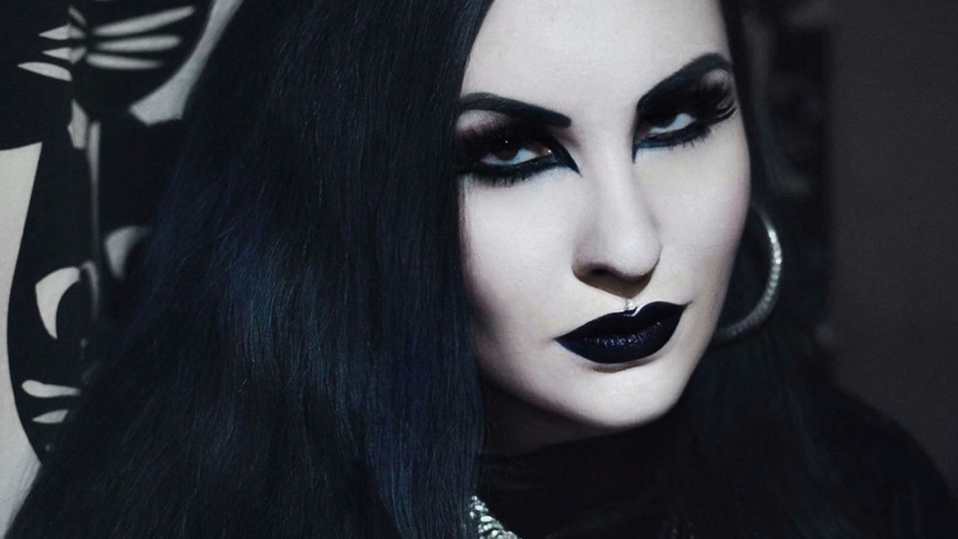 a woman with long black hair and black makeup