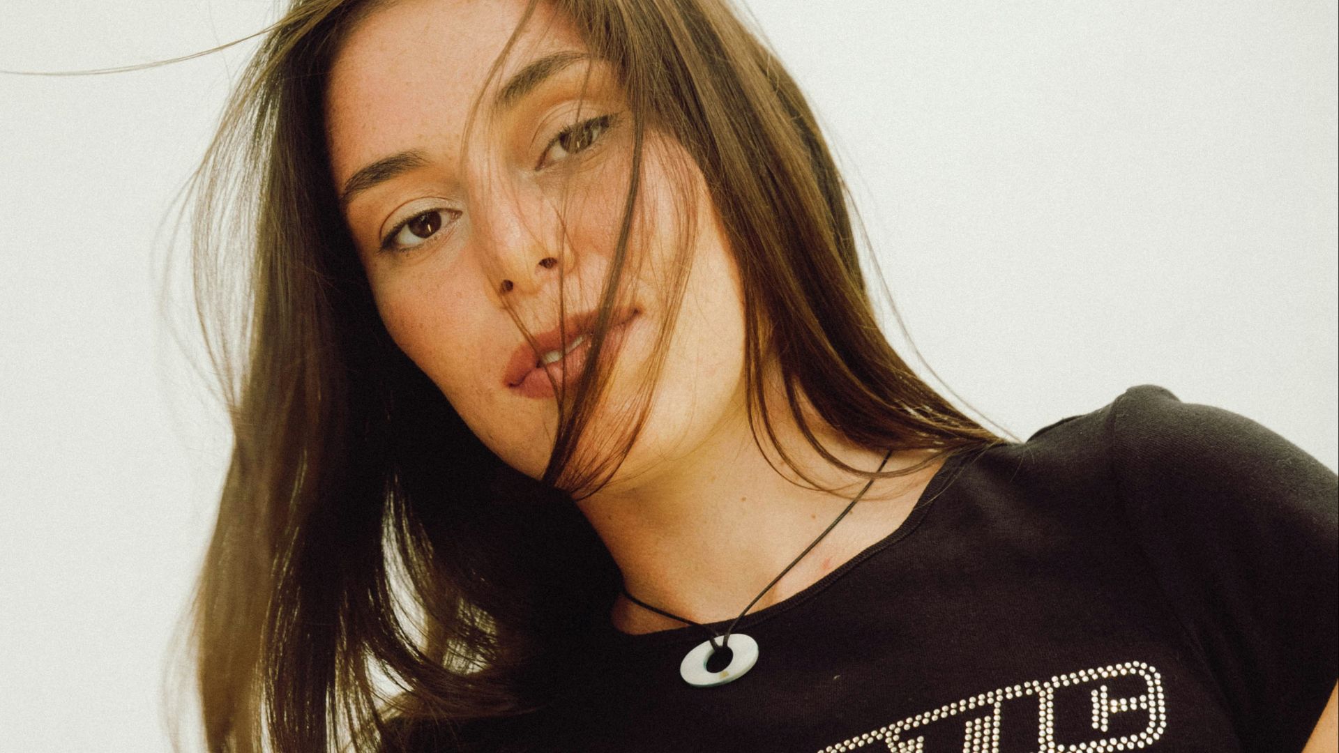 a woman in a black shirt with a cigarette in her mouth