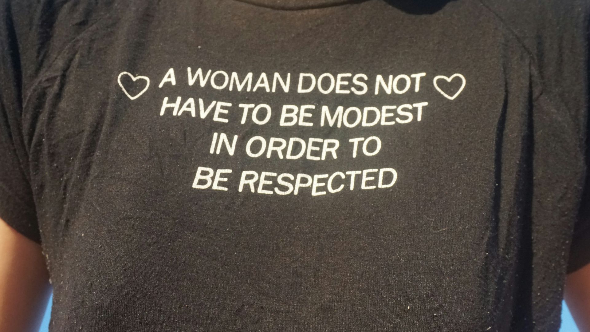 A woman wearing a t - shirt that says a woman does not have to be