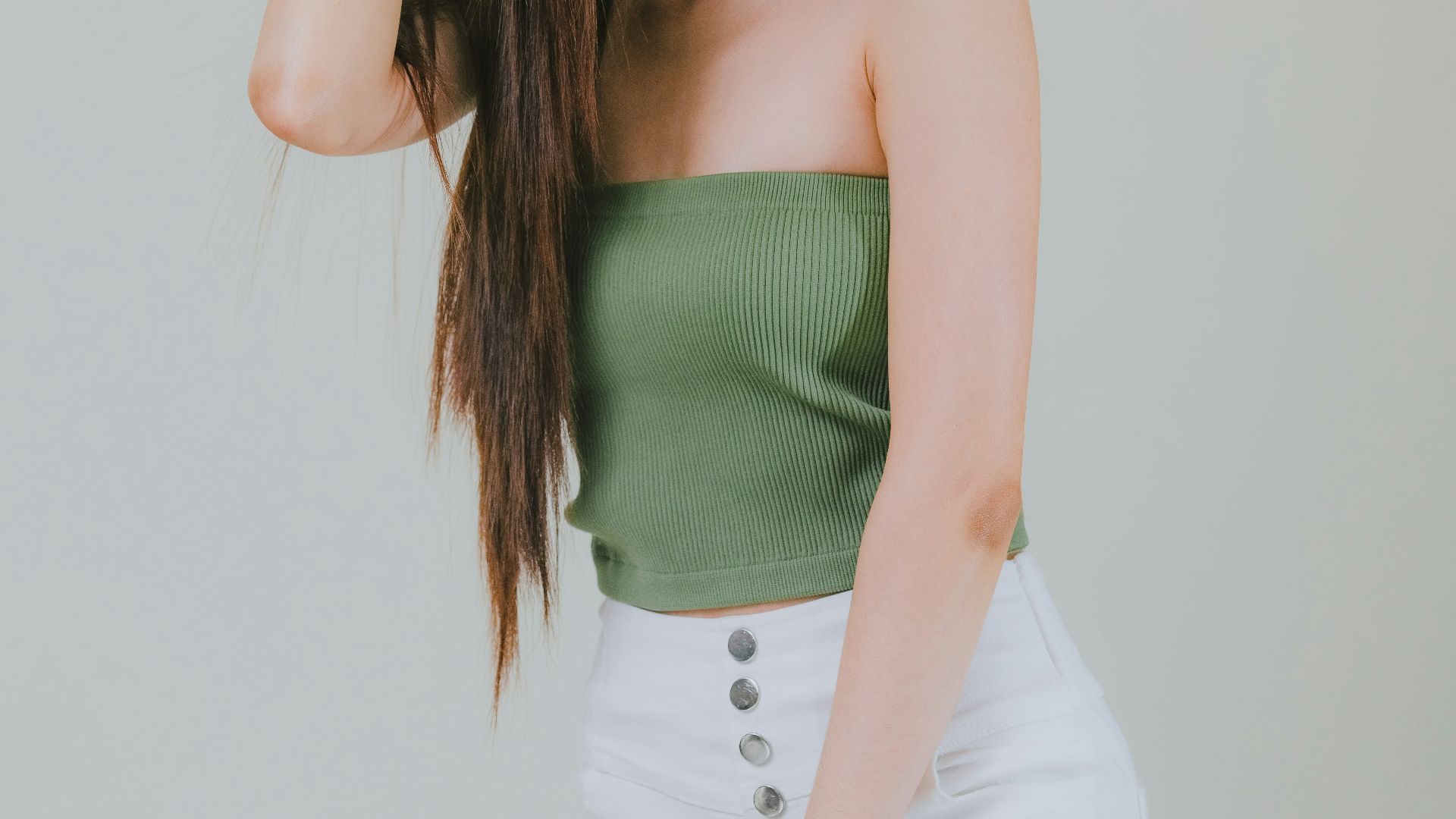 a woman in white pants and a green top