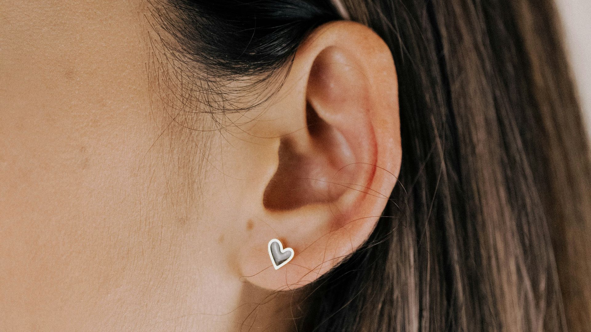 a close up of a person wearing a pair of earrings