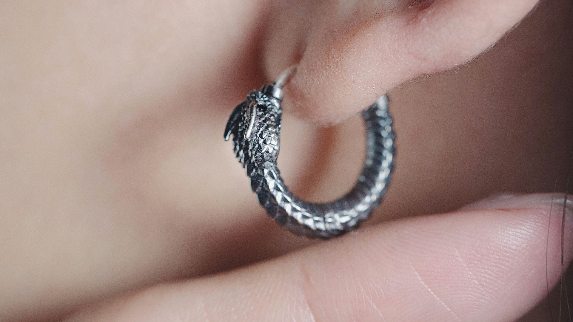 a close up of a person's ear with a ring on it