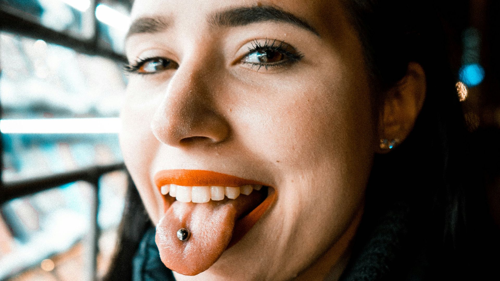 woman showing tongue with piercing