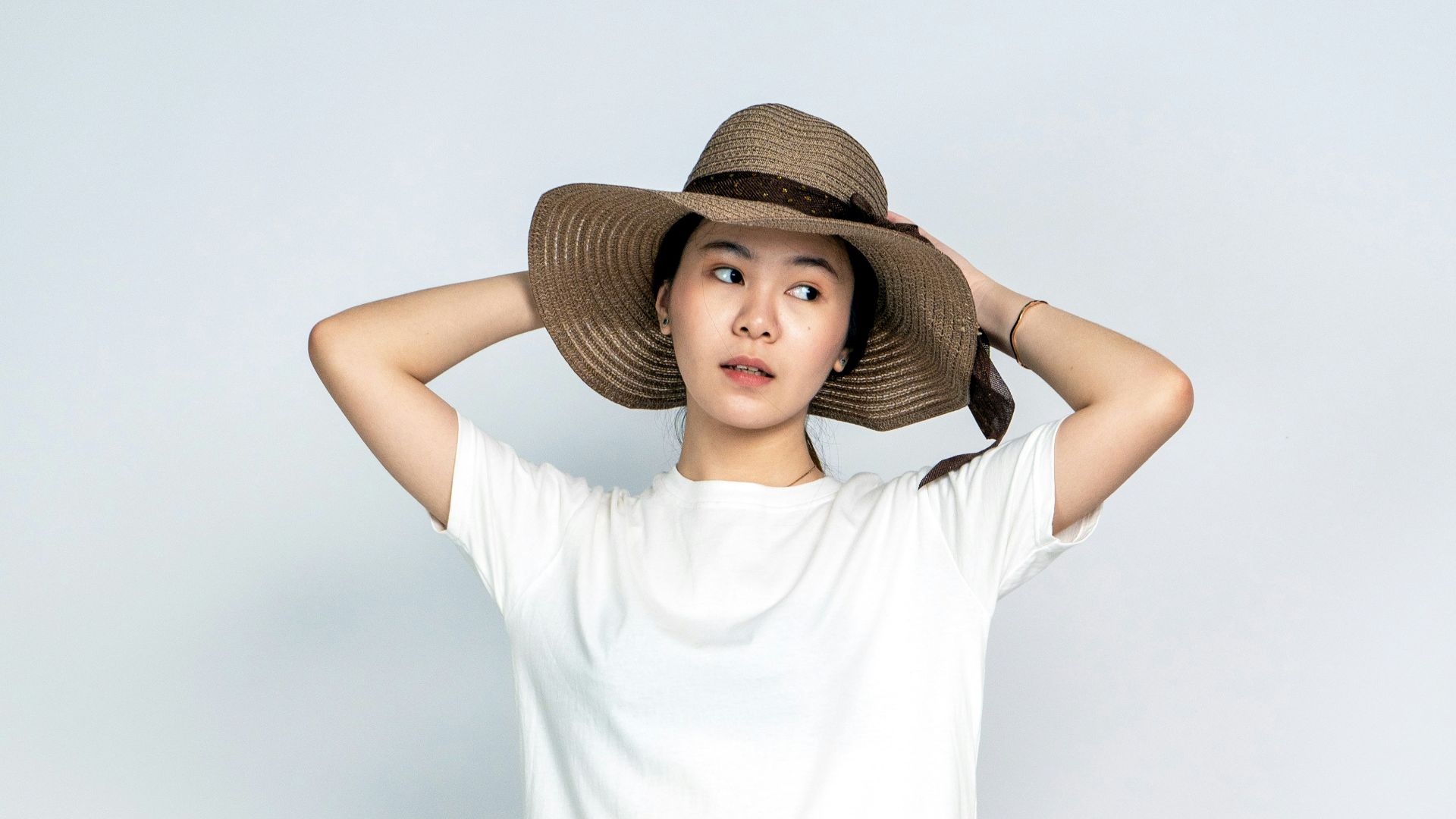 a woman wearing a white dress and hat