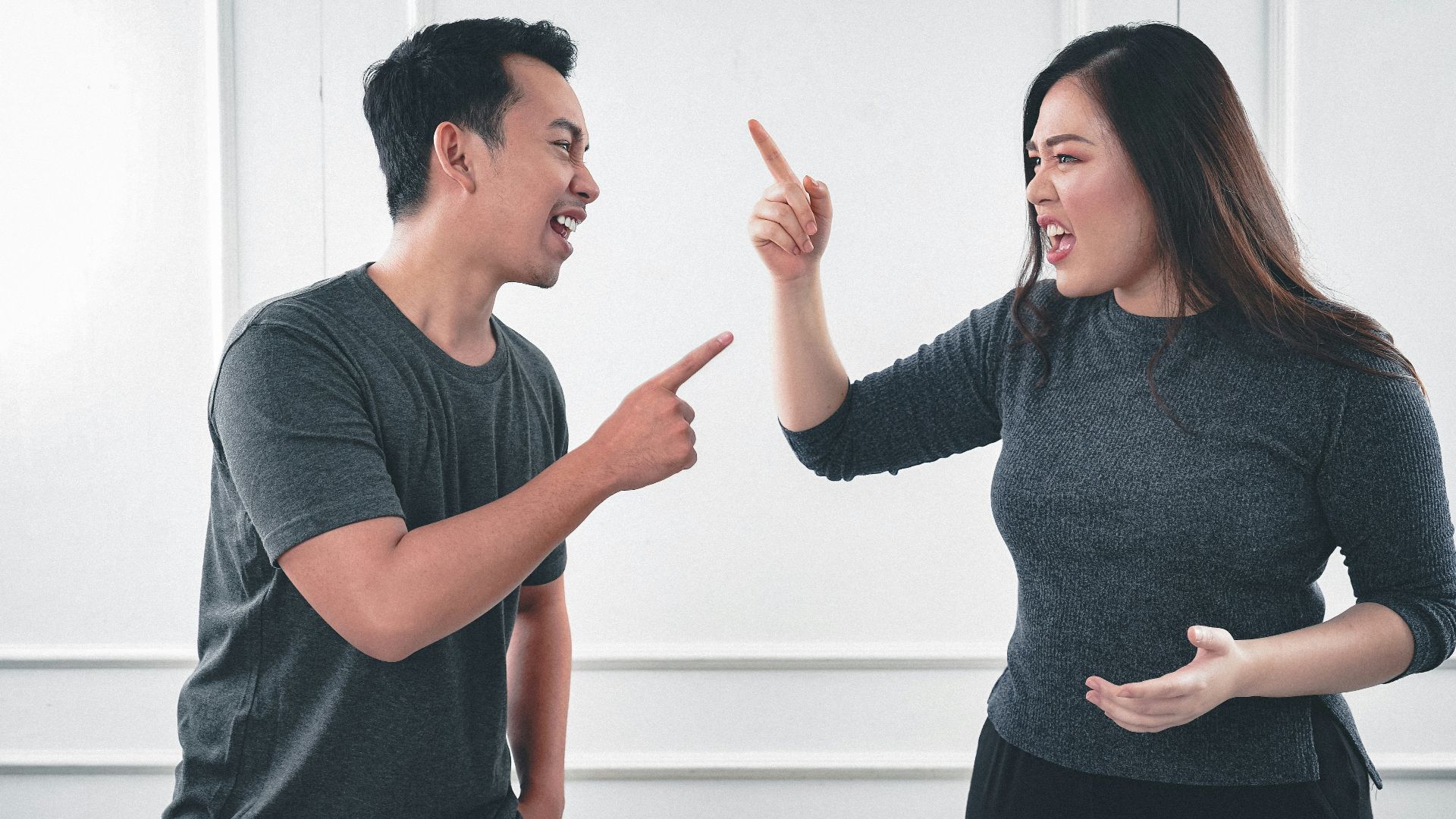 man in gray crew neck long sleeve shirt standing beside woman in black crew neck shirt