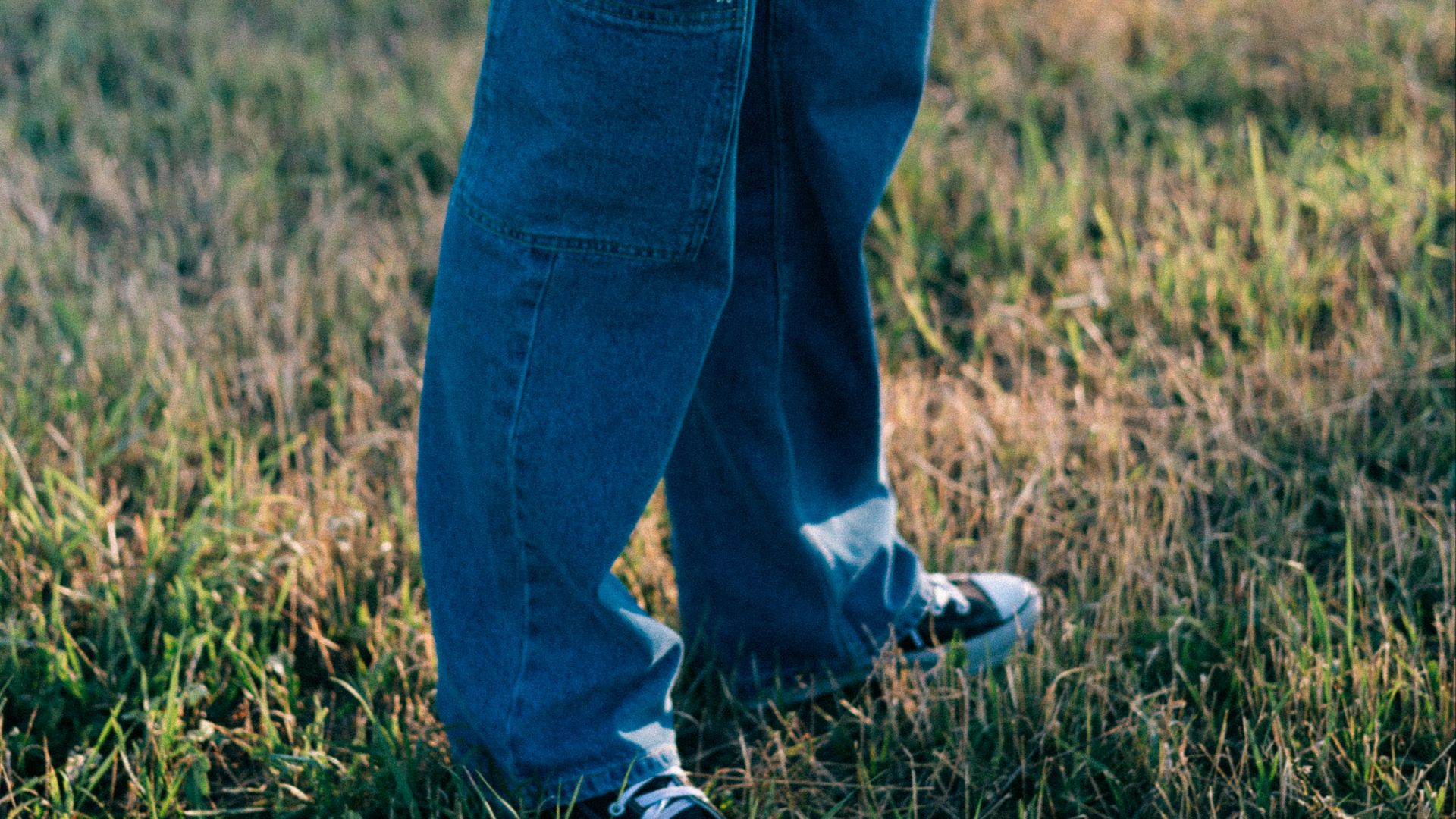 A person standing in a field holding a frisbee