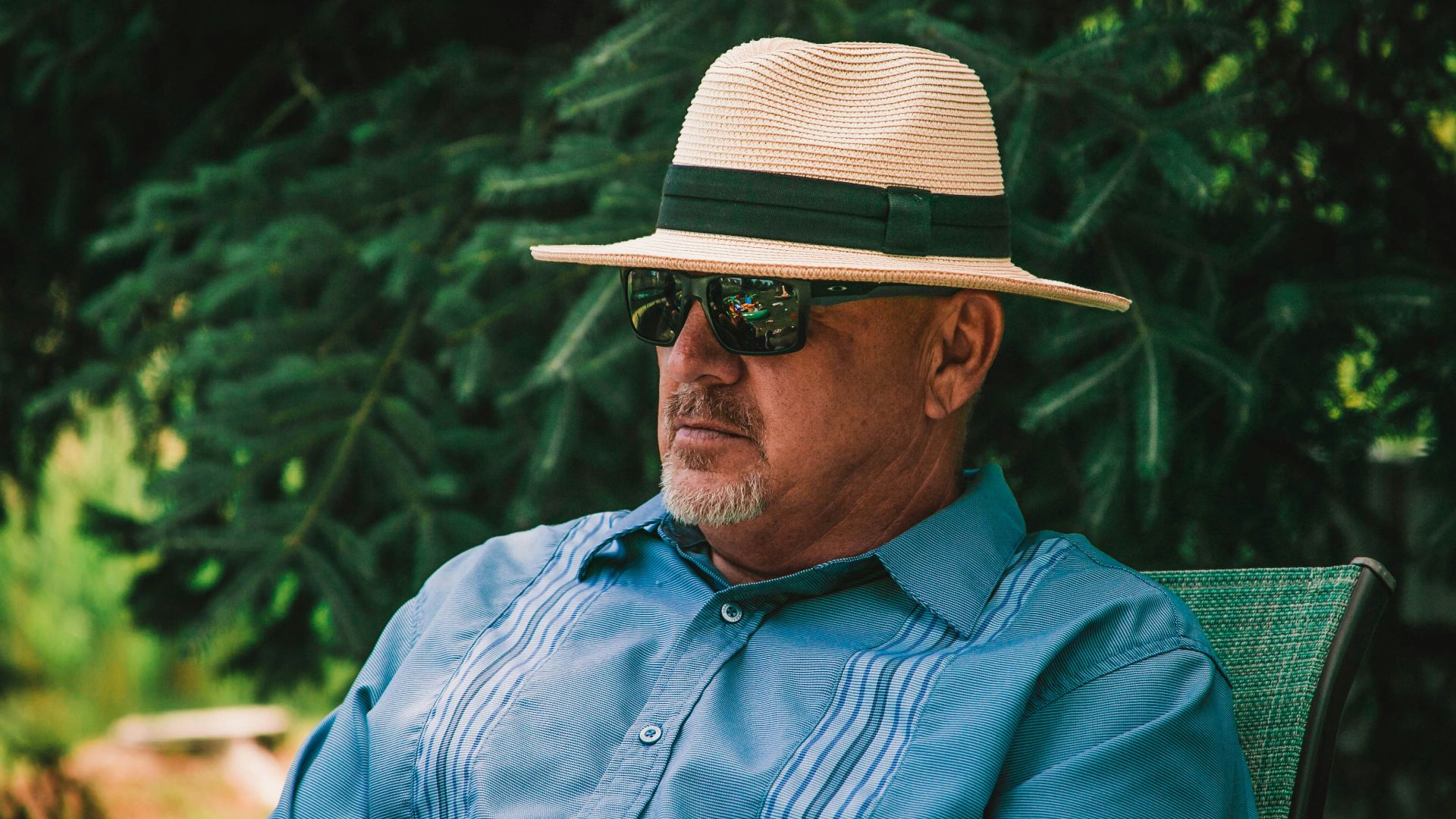 man in blue dress shirt wearing brown fedora hat