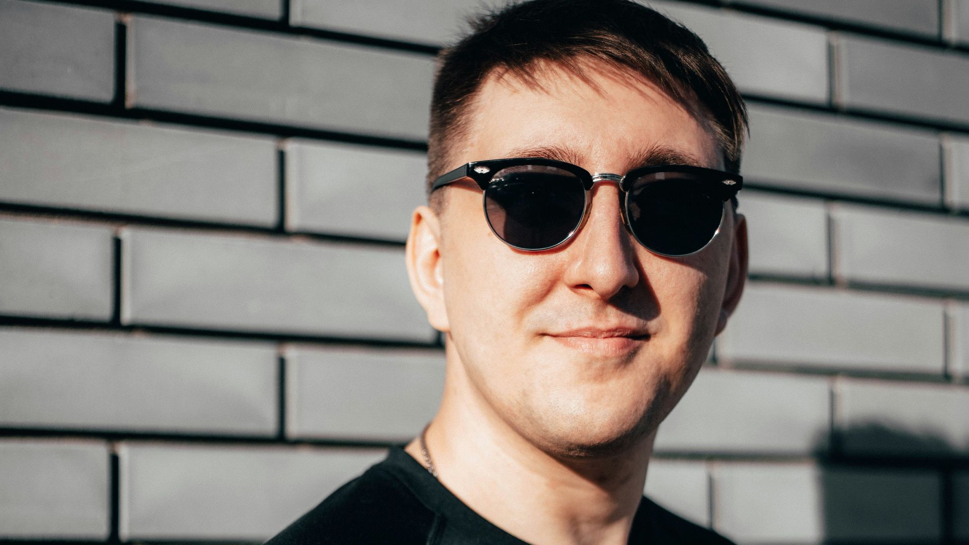 man in black crew neck shirt wearing black sunglasses