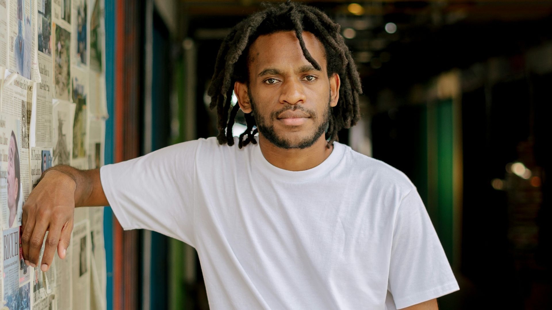 man in white crew neck t-shirt wearing black headphones