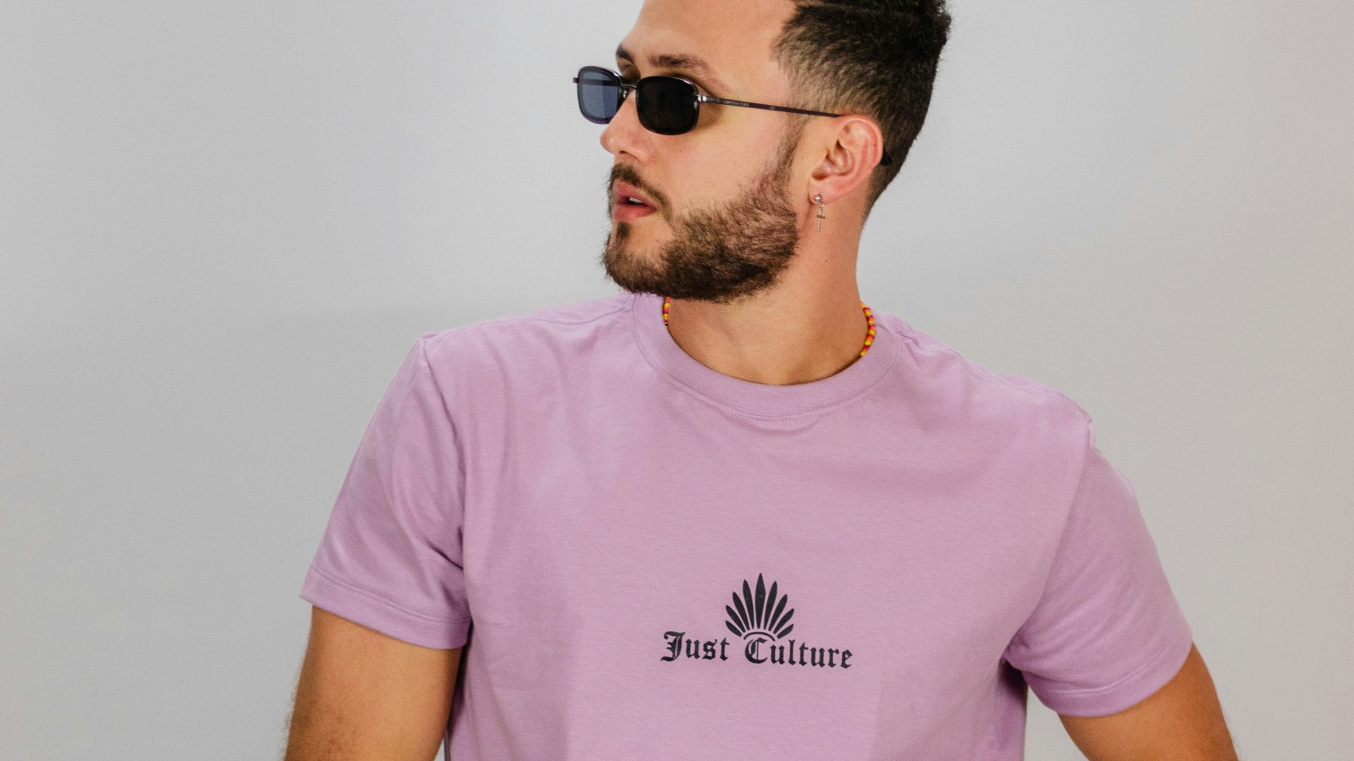 man in pink crew neck t-shirt wearing black sunglasses