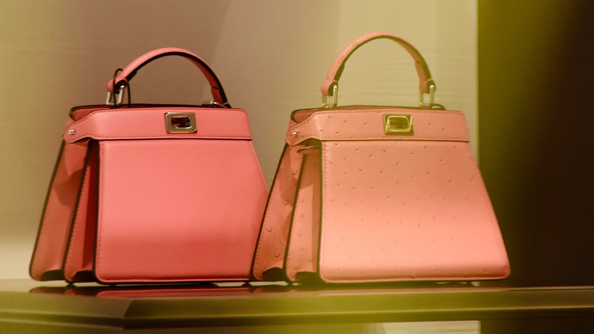 two pink bags are on a shelf in a store