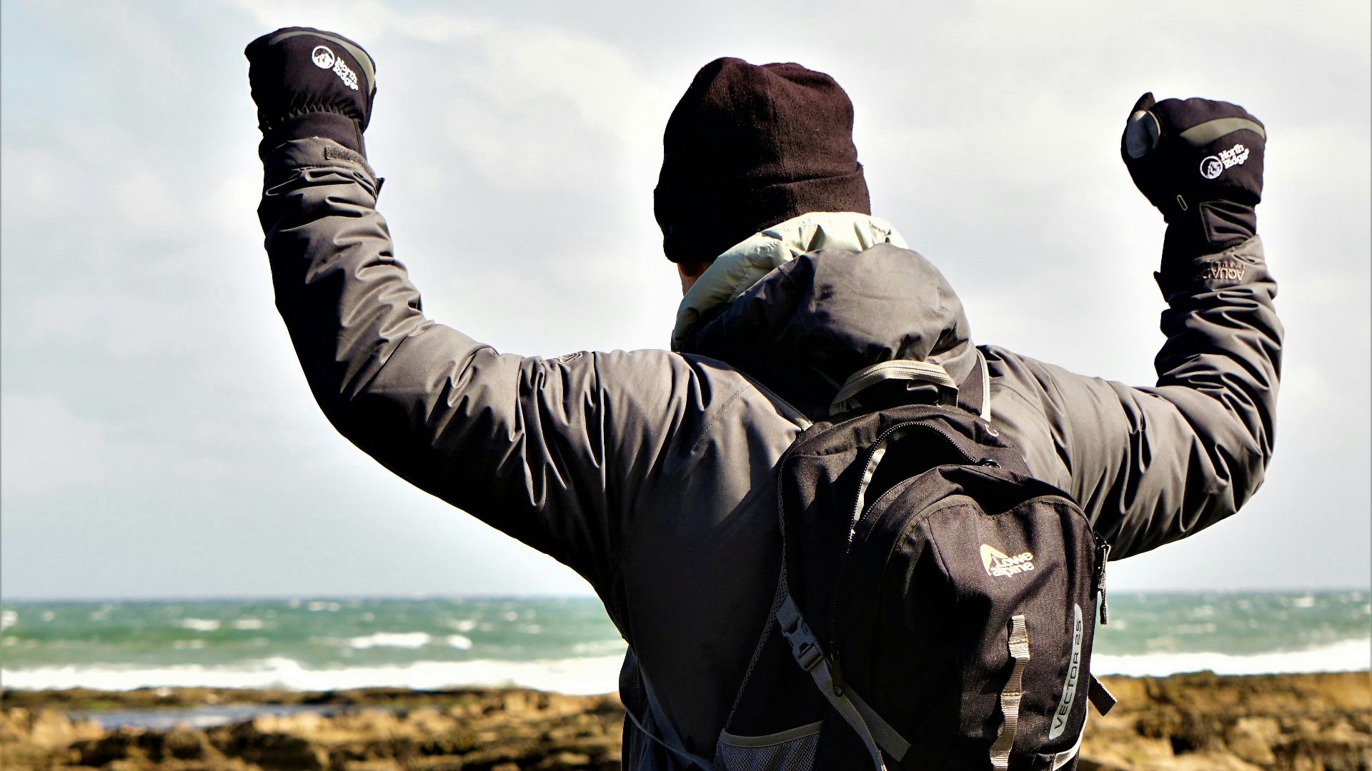 man in black jacket and gray pants standing on brown field during daytime