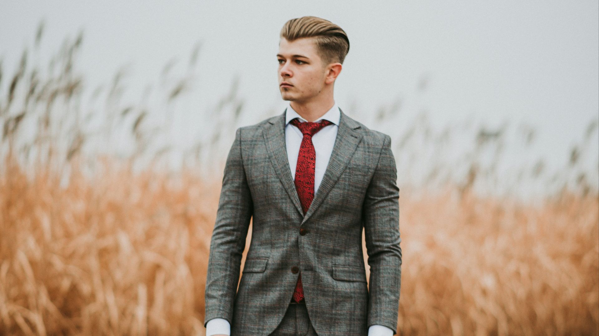 man standing near brown grass field on selective focus photography