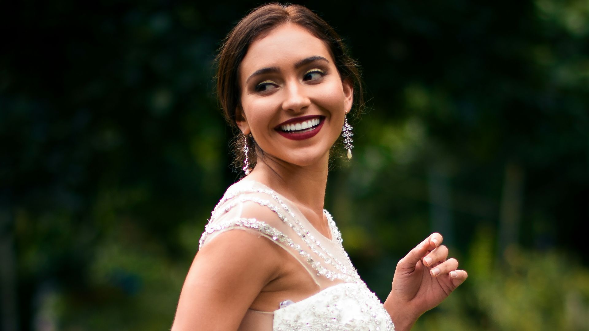 woman in white floral dress holding bouquet of flowers
