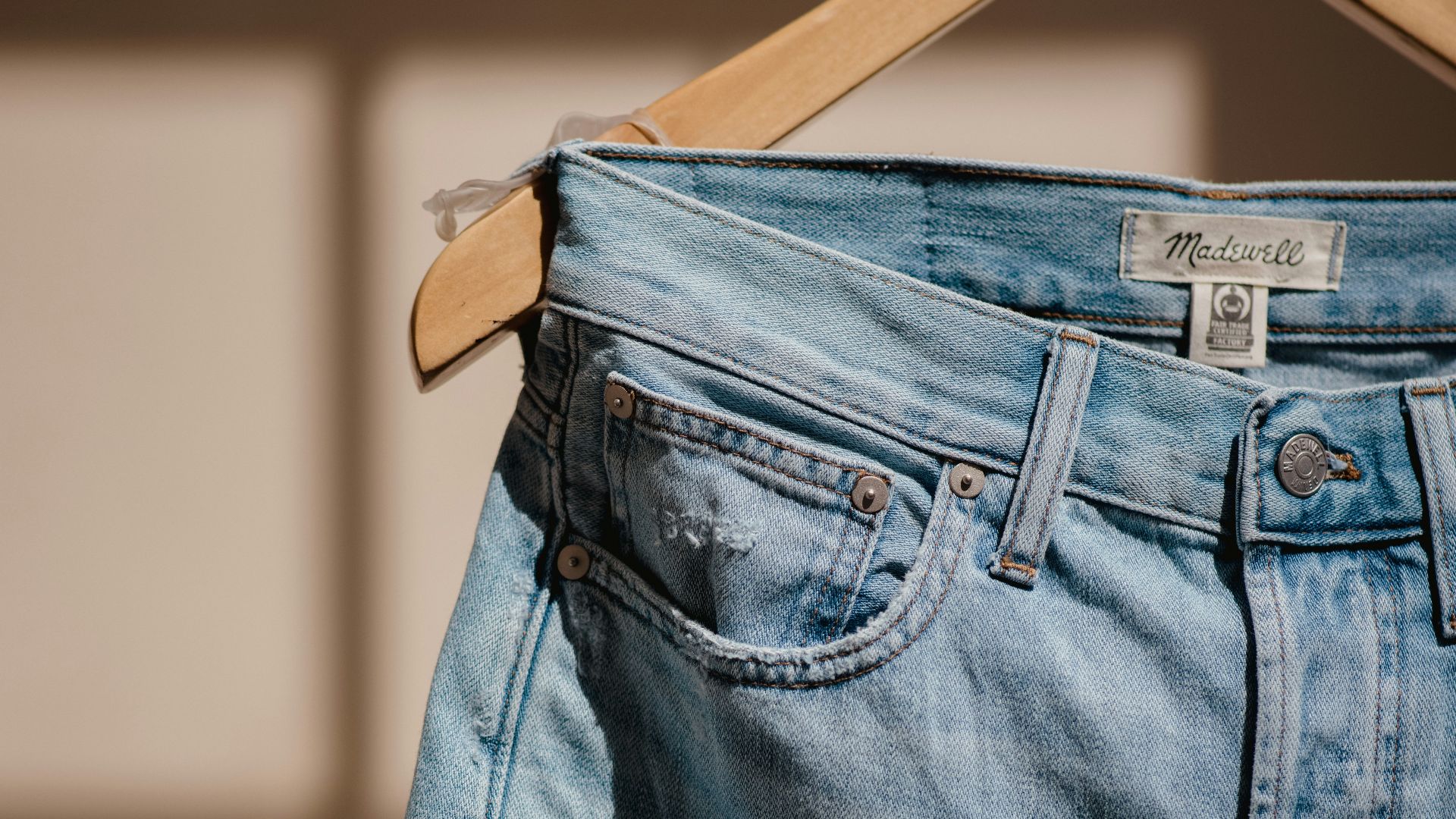 blue denim jeans on brown clothes hanger