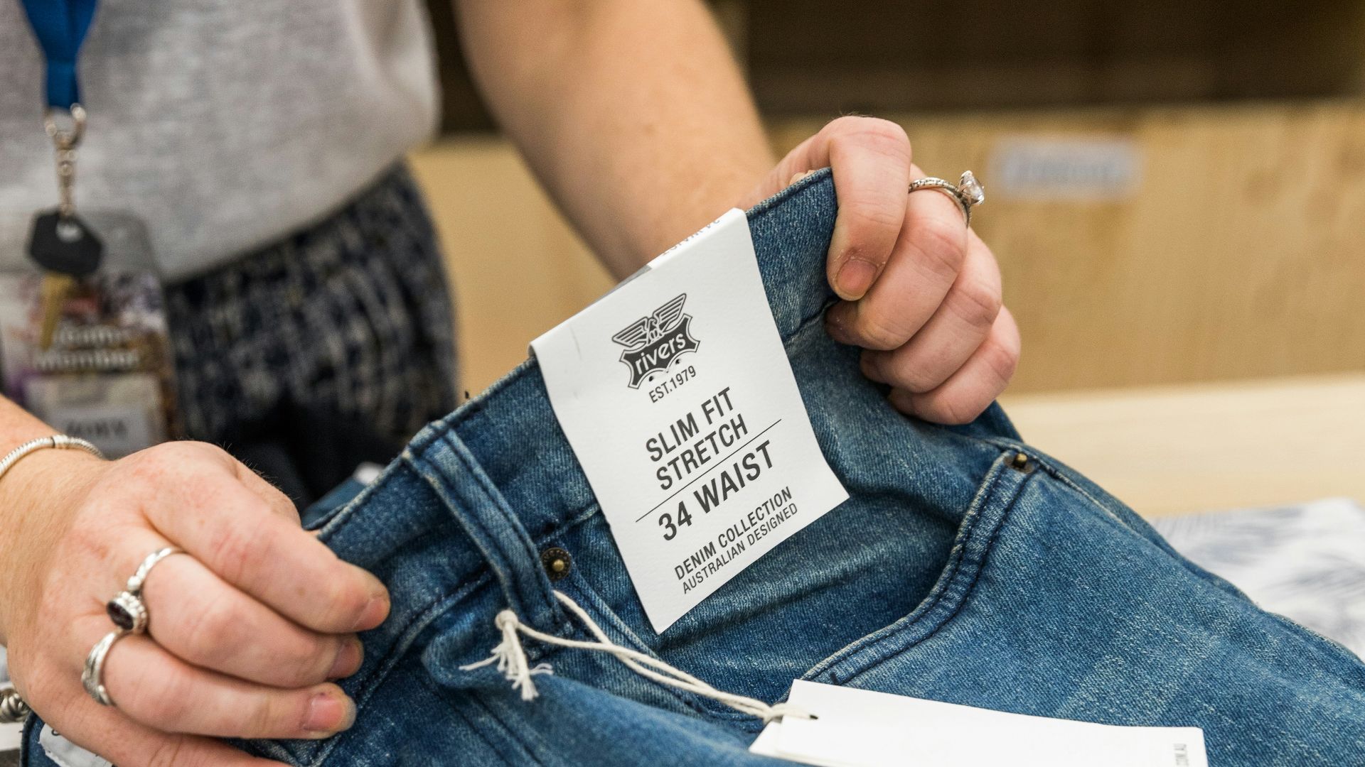 person in blue denim jeans holding white paper