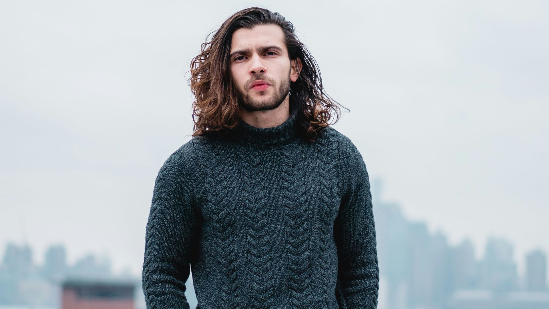 woman in gray sweater standing on brown wooden dock during daytime