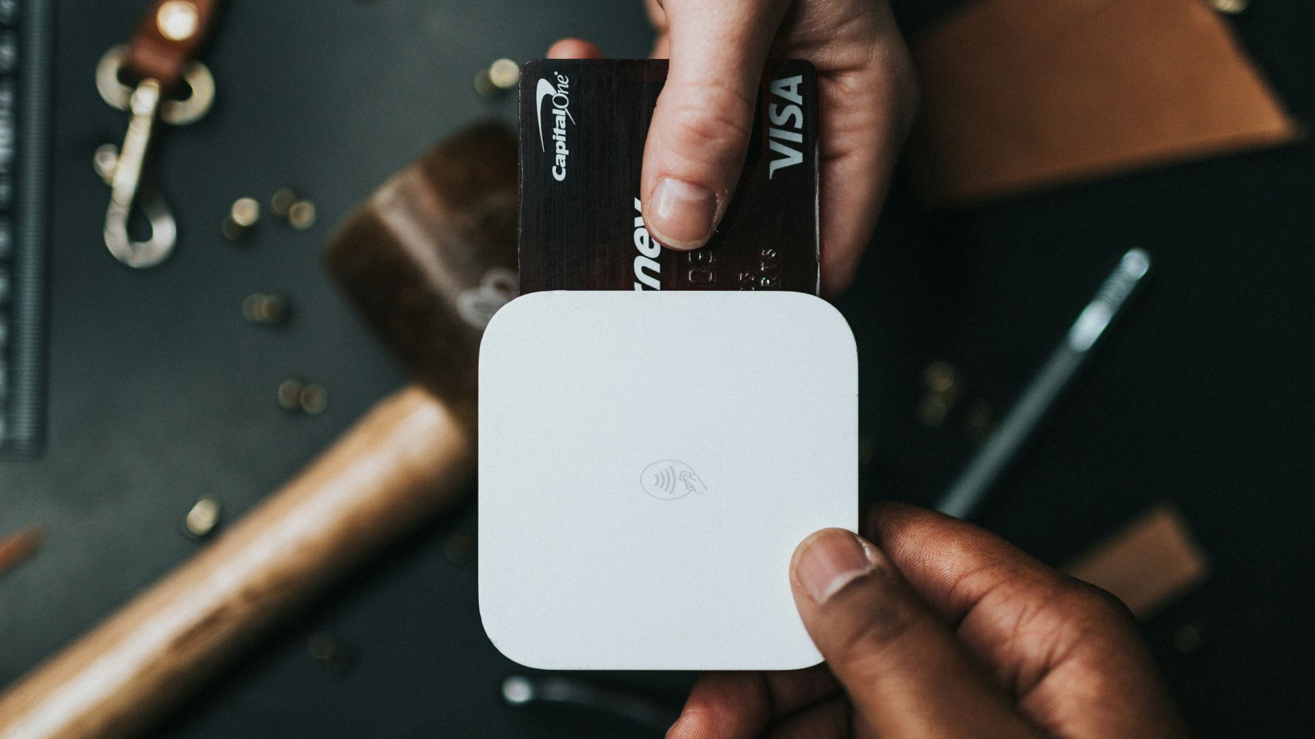 person holding Visa card and white device
