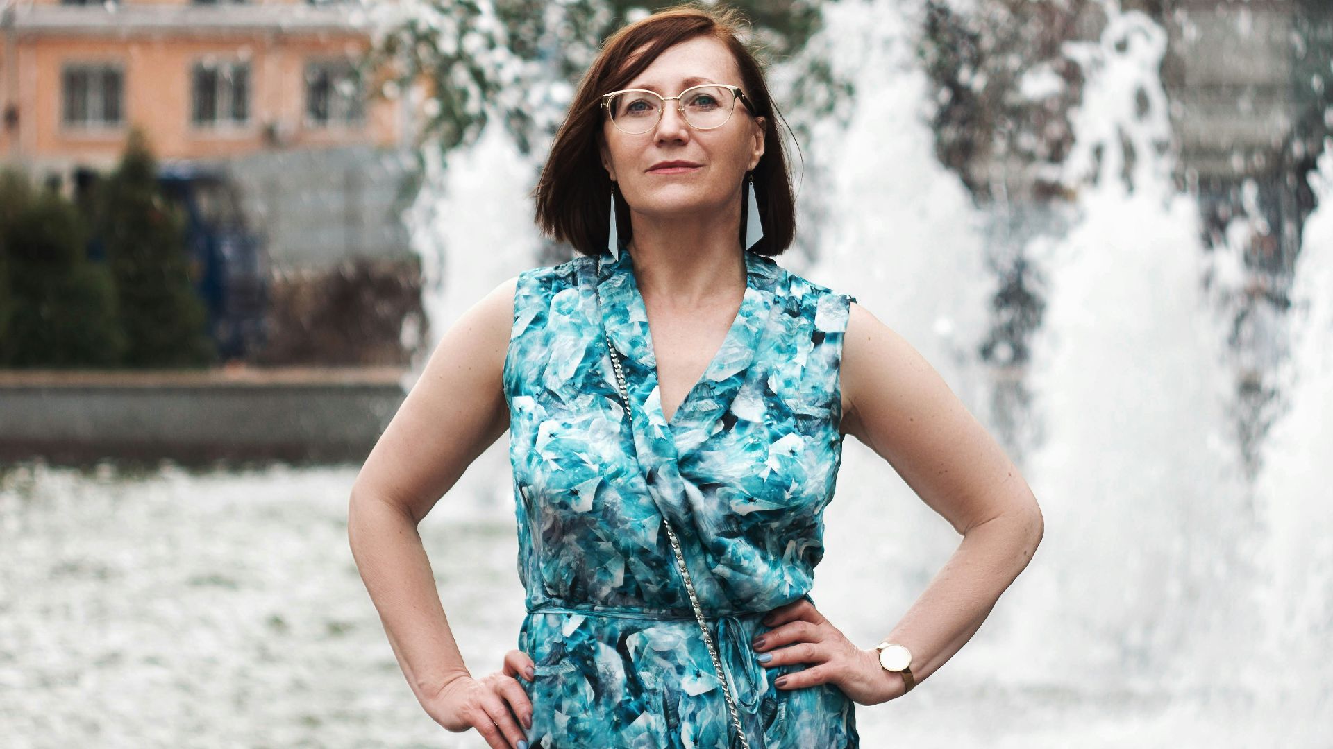 woman in blue and white floral sleeveless dress standing on snow covered ground during daytime