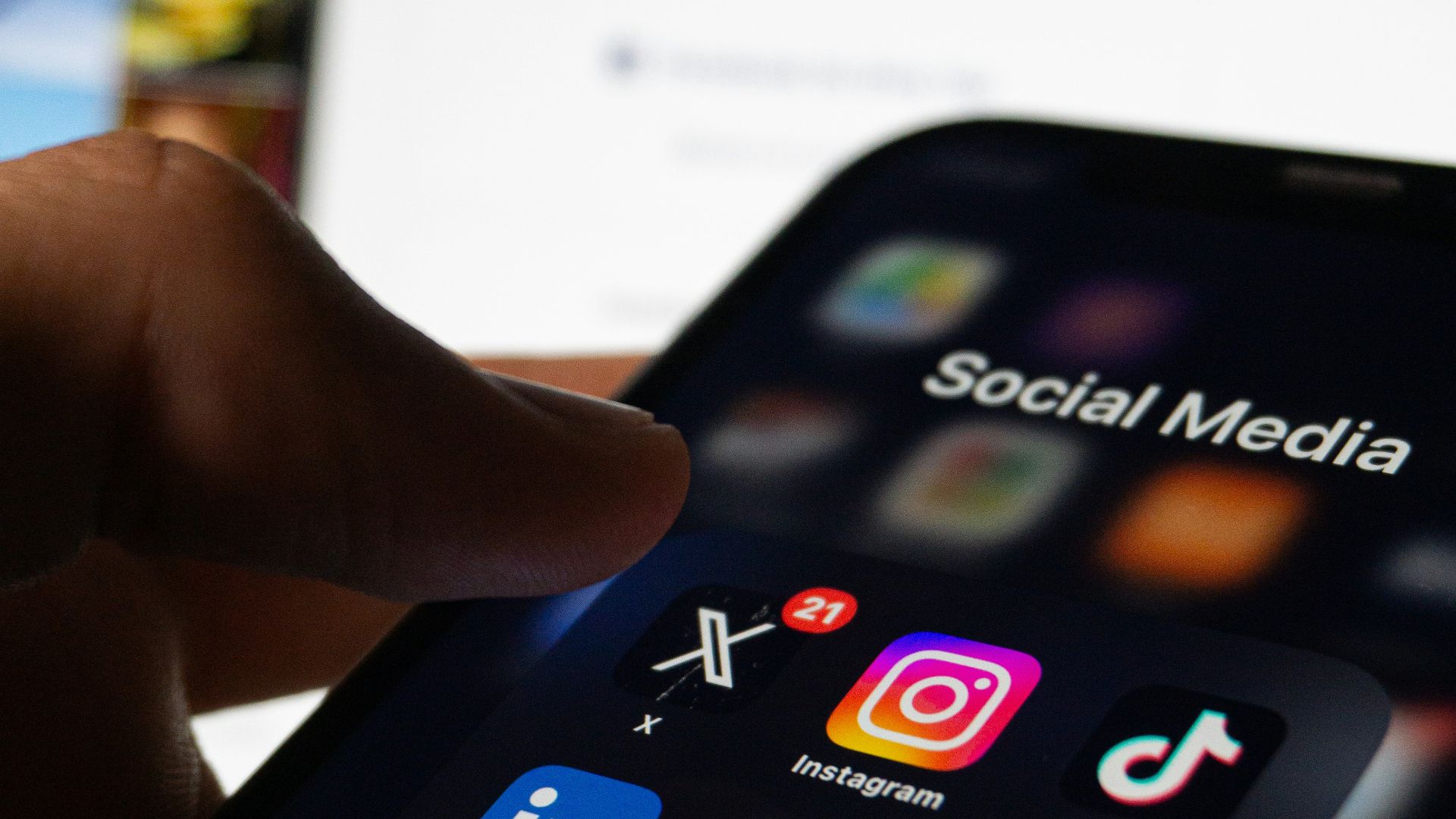 A person holding a smart phone with social media on the screen