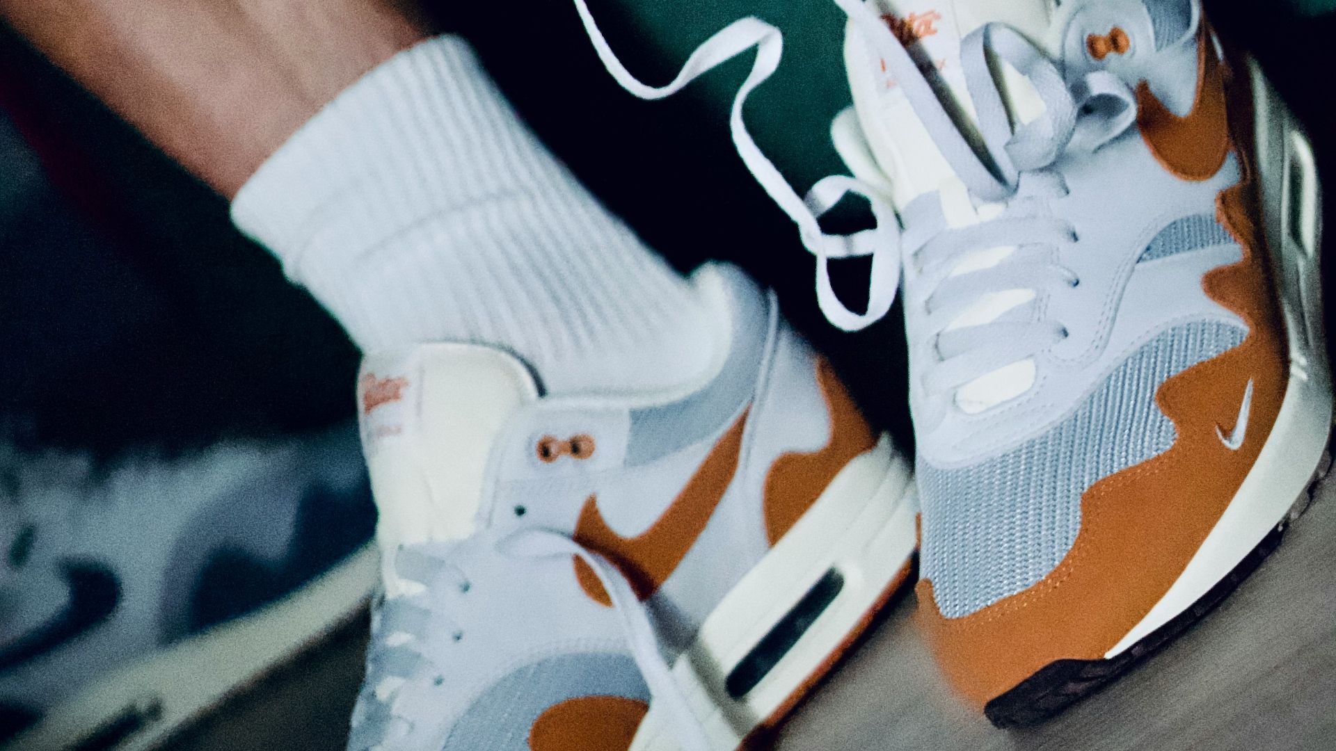 a close up of a person's feet wearing white and orange sneakers