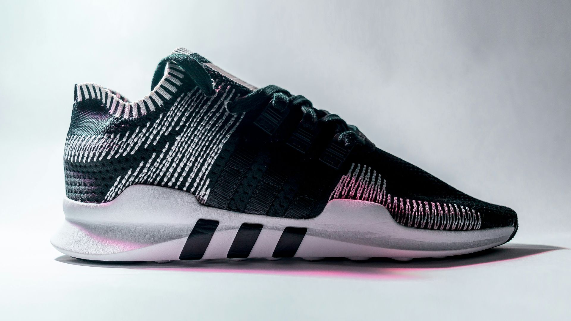 unpaired black and white Adidas low-top sneaker