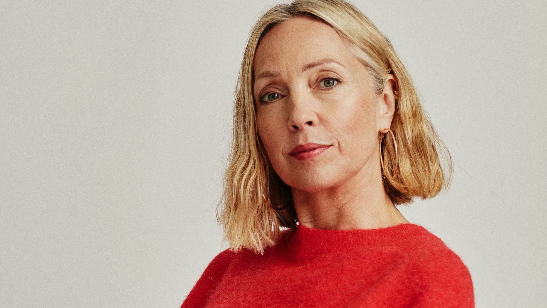 a woman sitting on a chair holding a cup of coffee