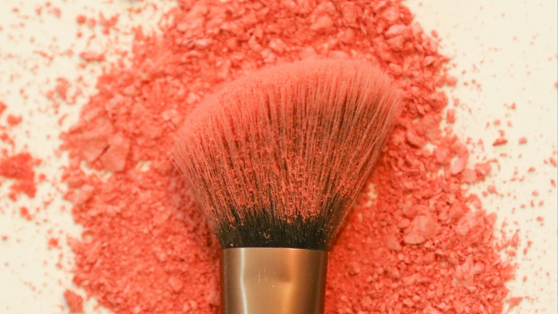 A makeup brush with scattered coral powder