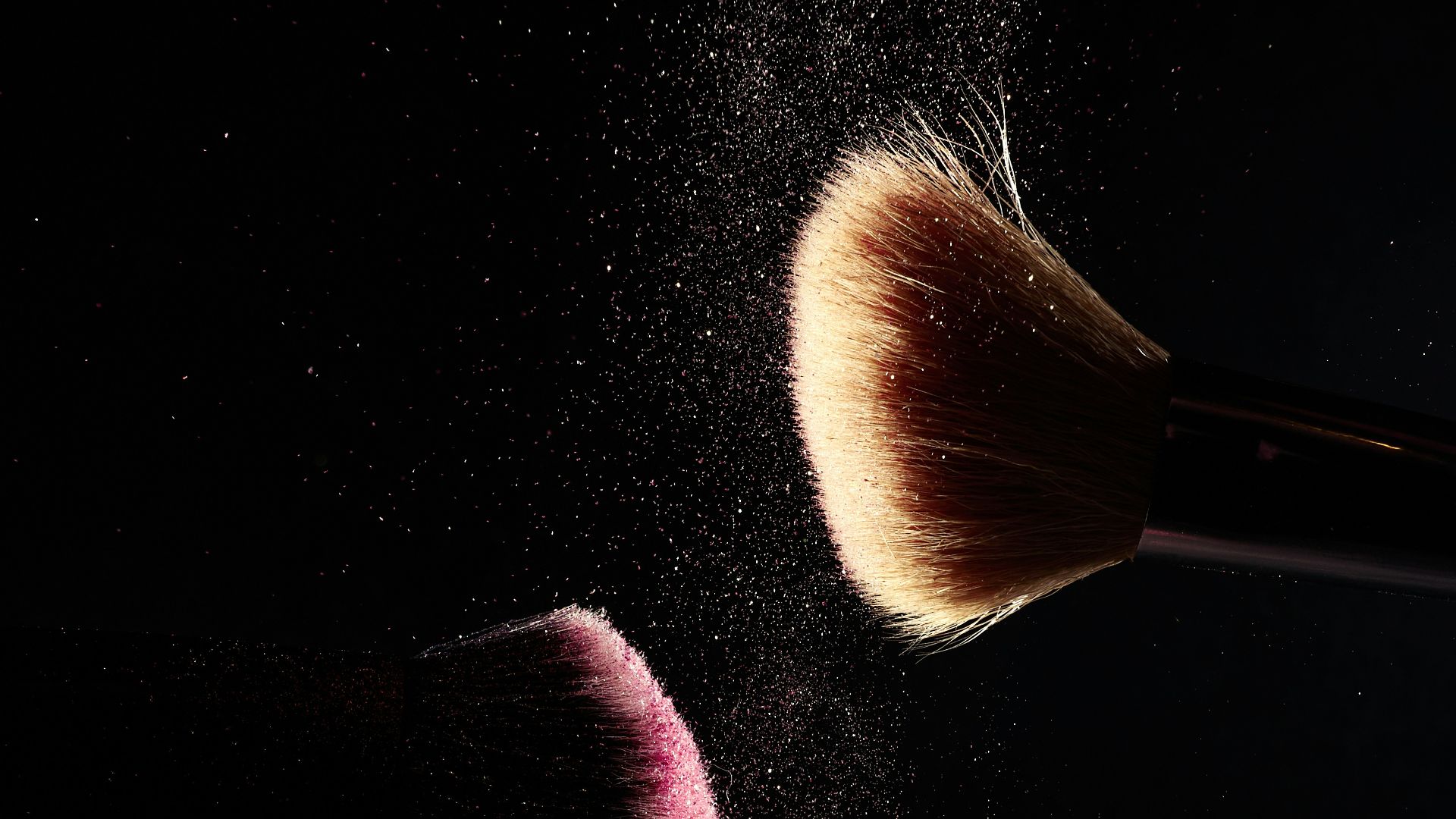 a close up of two makeup brushes on a black background