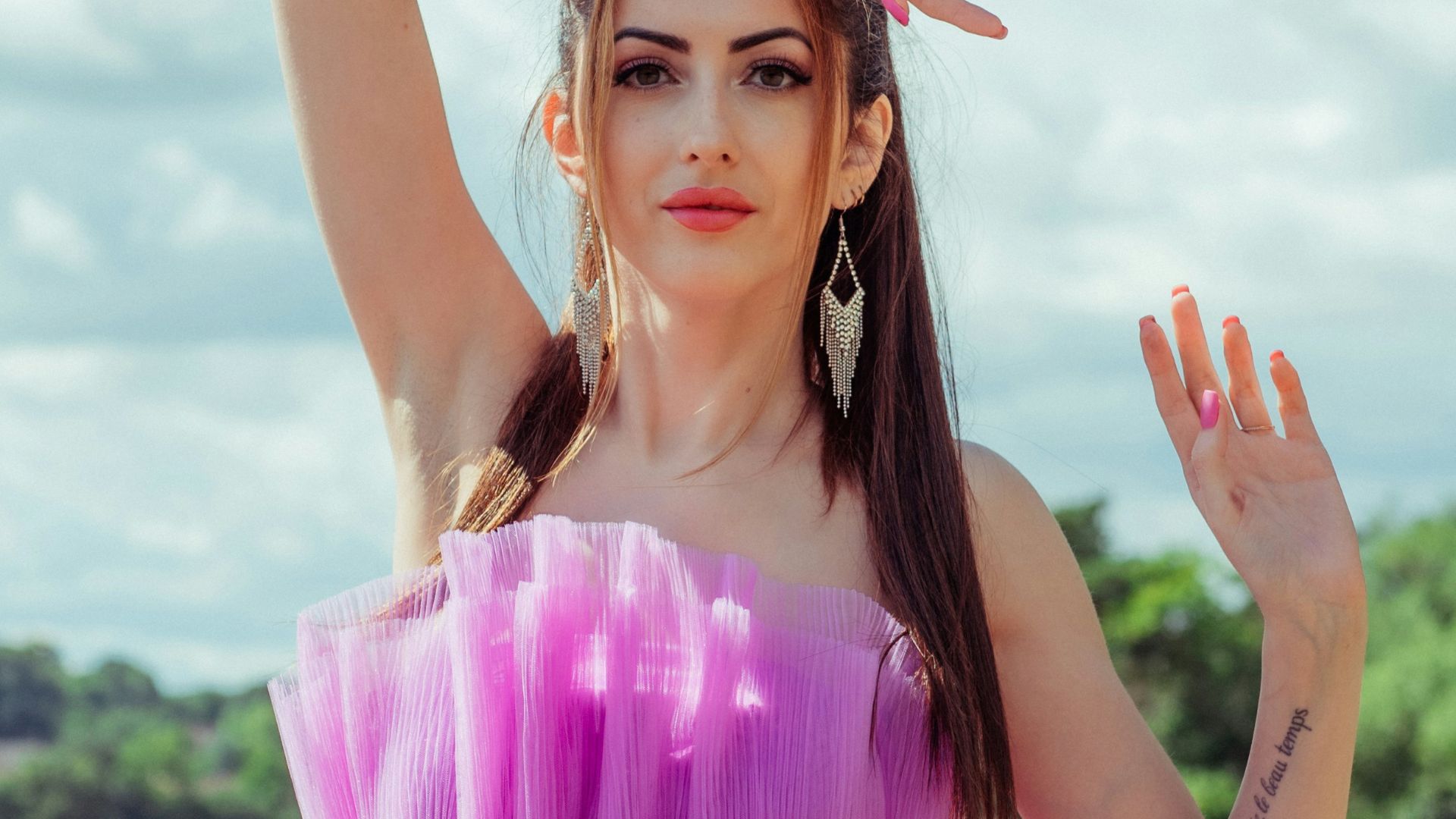 a woman in a purple dress standing in a field