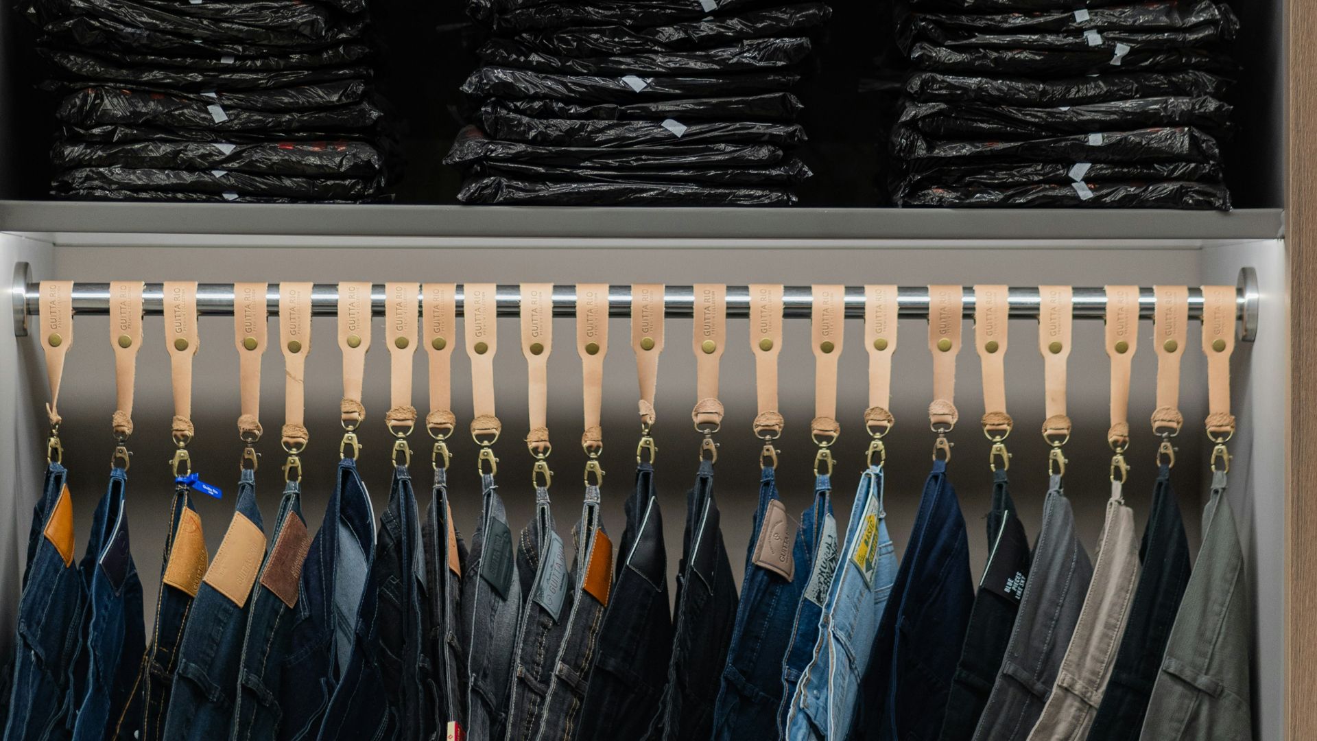 a closet filled with lots of shirts and pants
