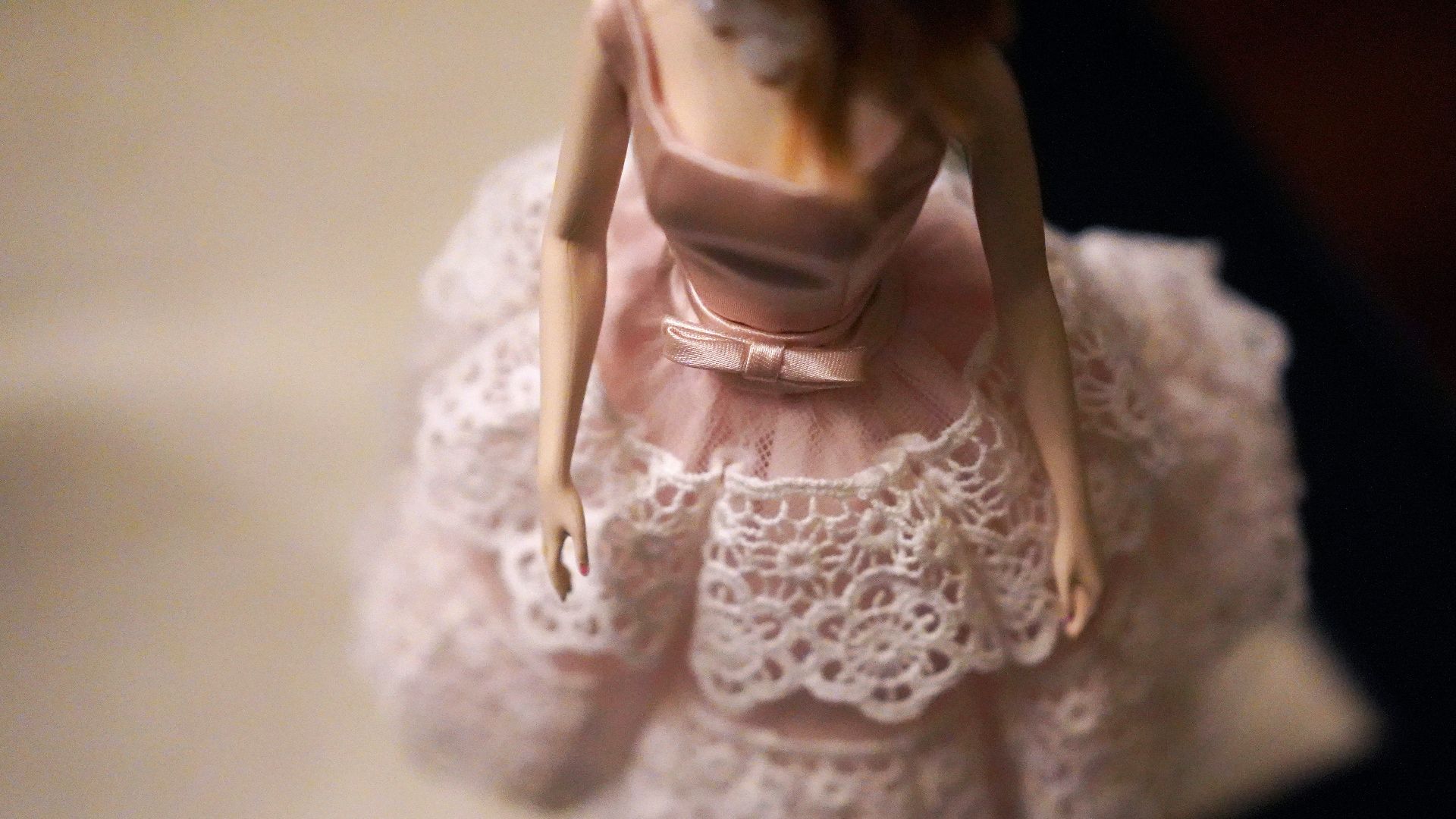 close-up of female doll wearing pink and white dress