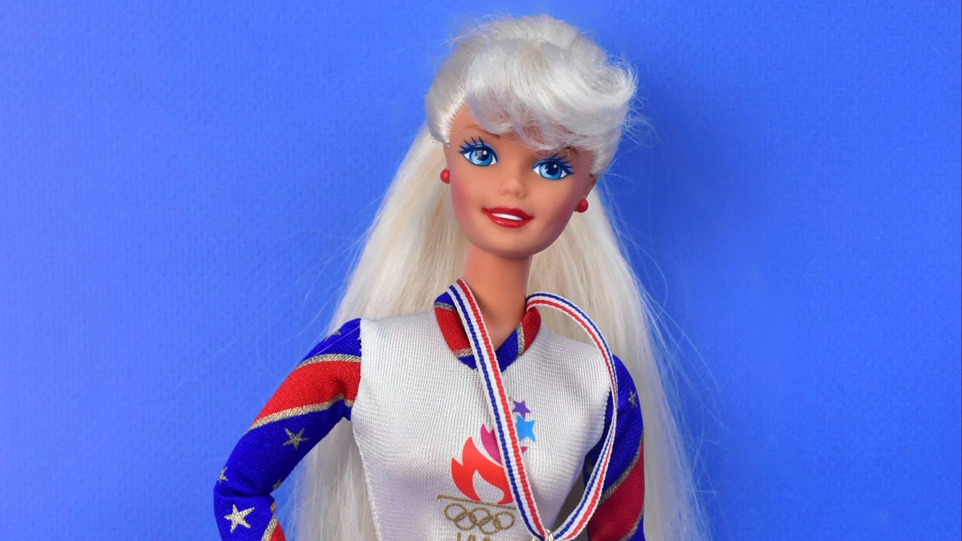 A barbie doll with a medal around her neck