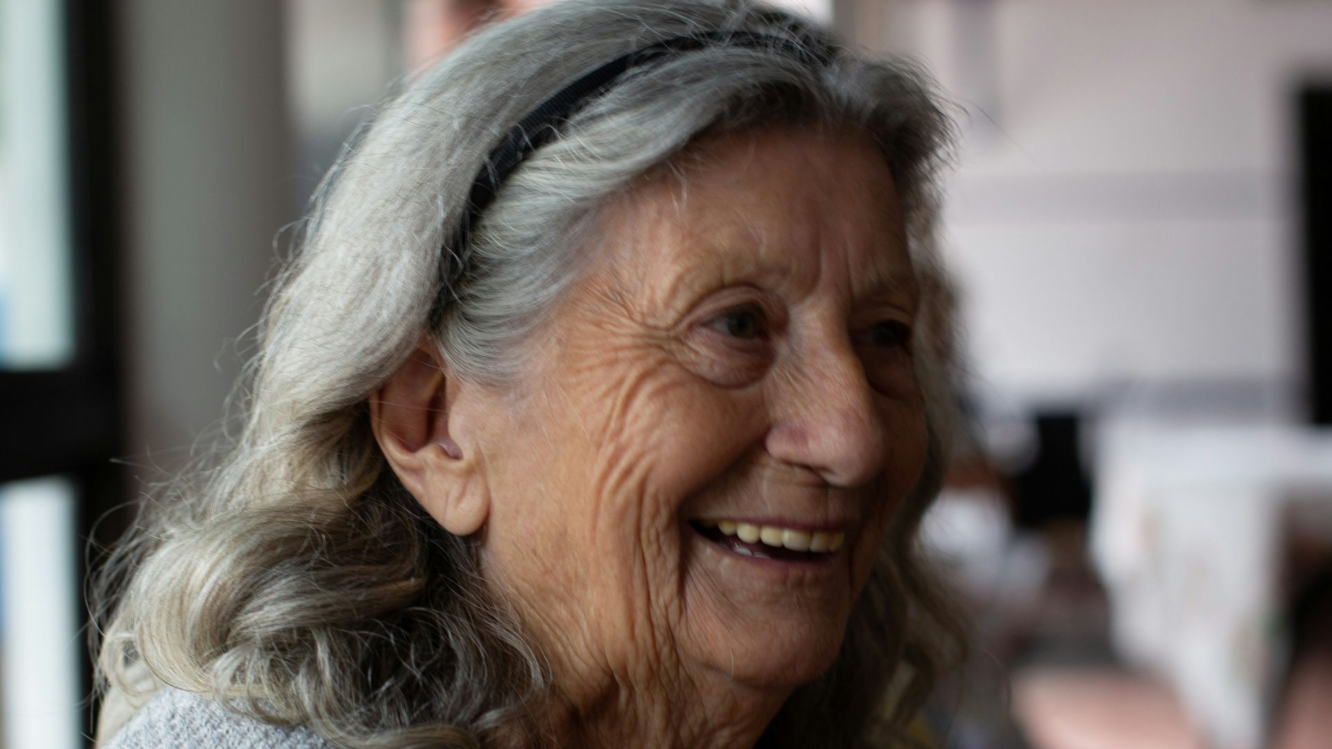 smiling woman in gray cardigan
