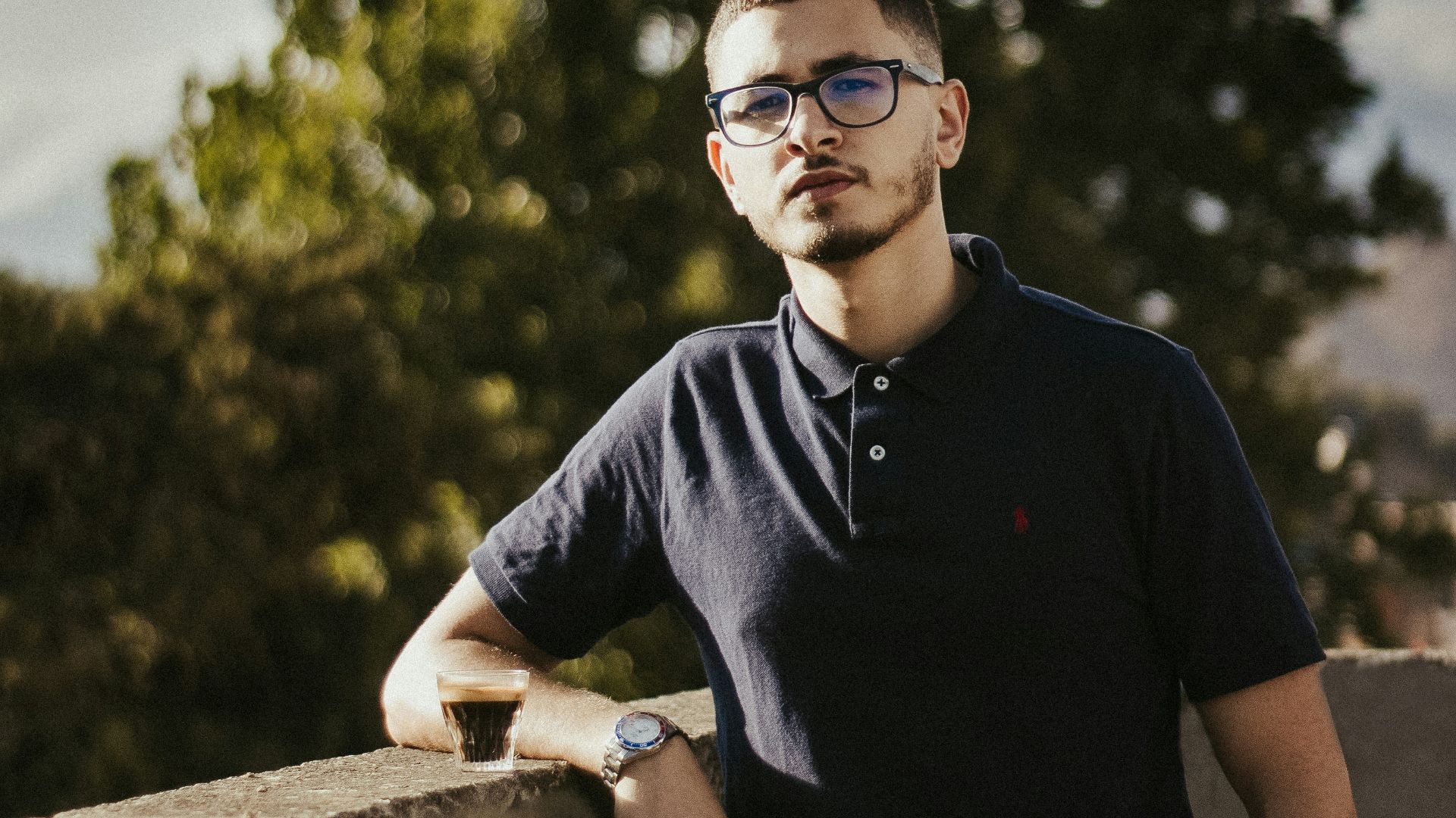 a man leaning on a wall with his hands on his hips