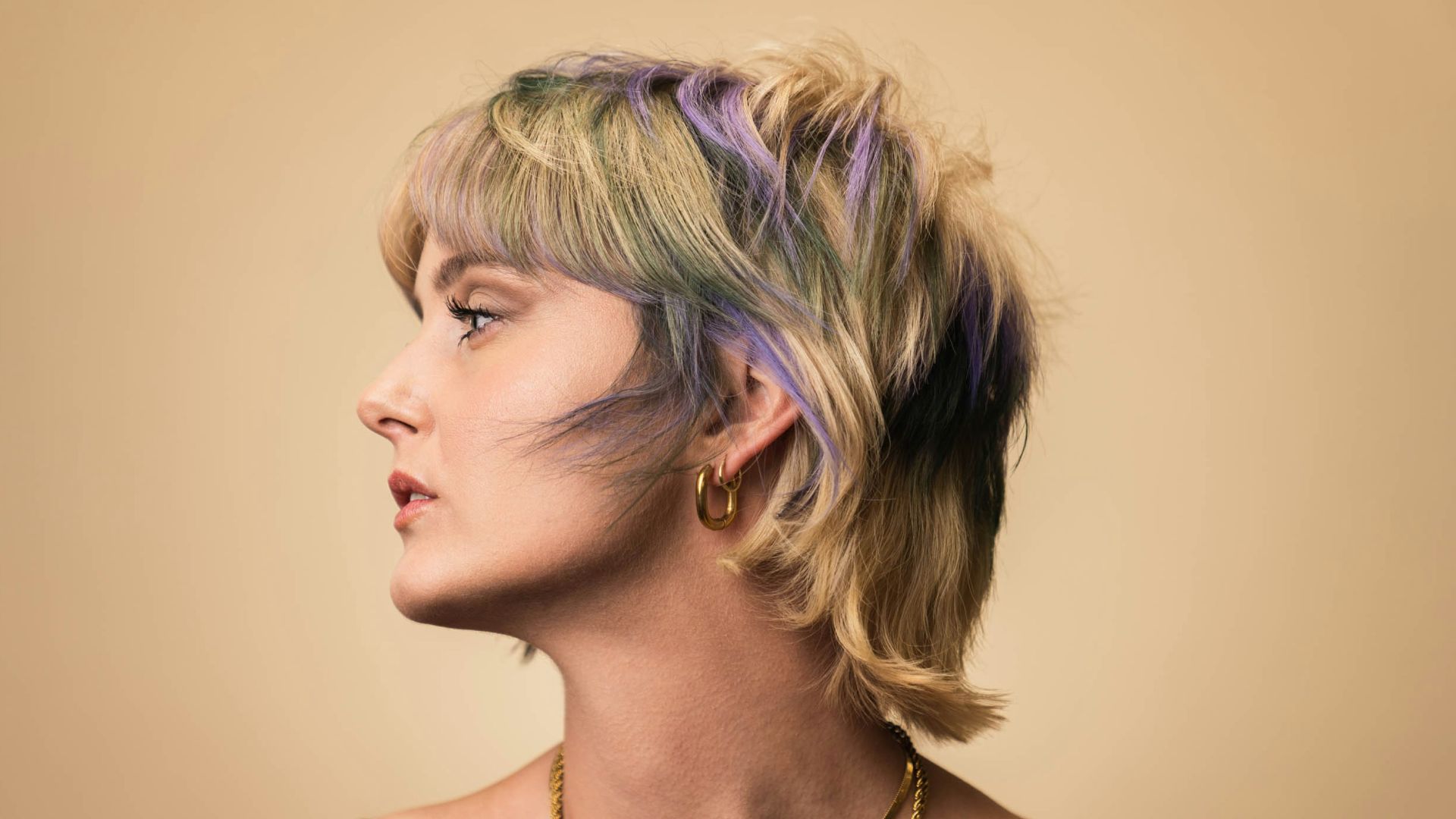 a woman with blonde hair wearing a necklace