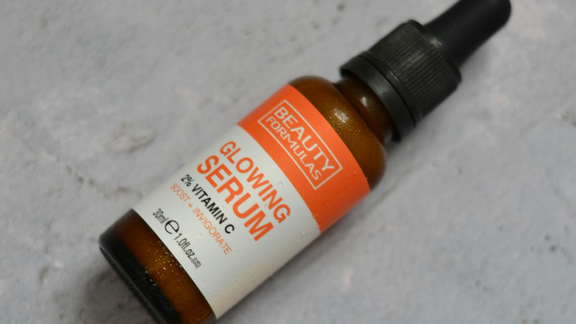 A bottle of vitamin oil sitting on top of an orange