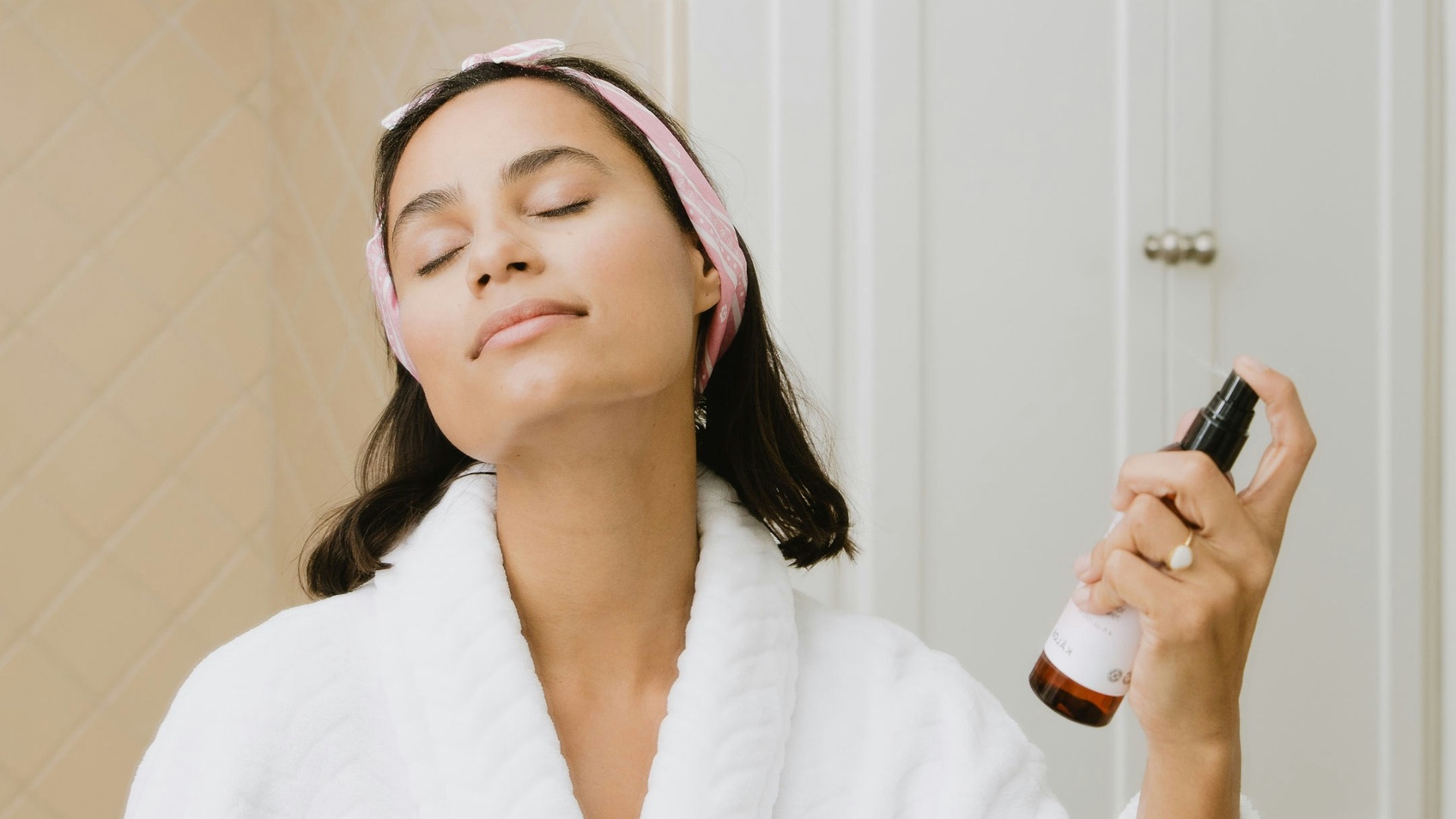 woman in white bathrobe holding smartphone